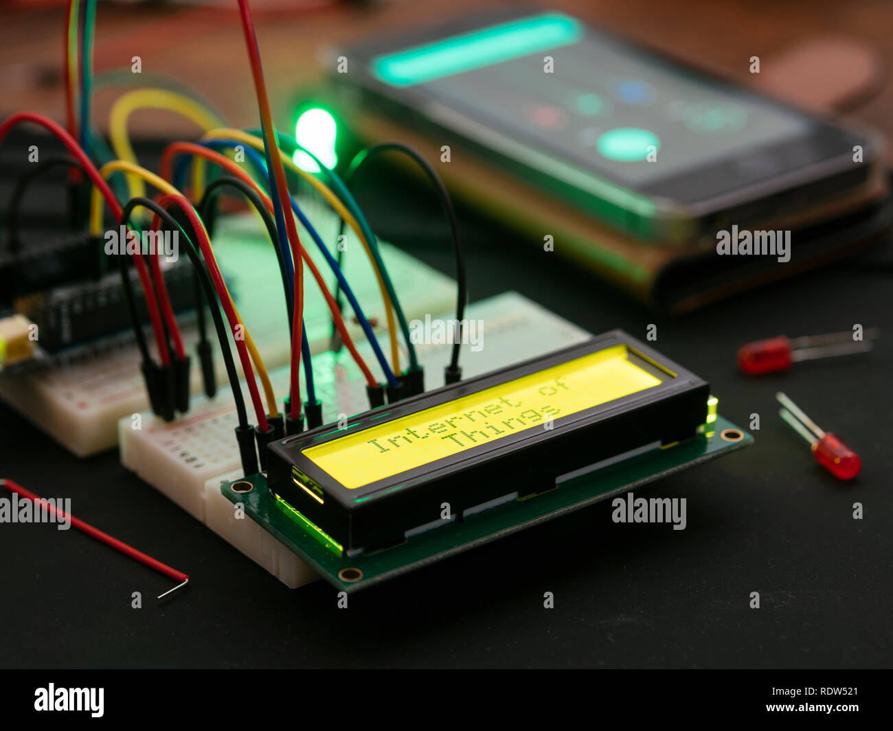 LCD-Anzeige auf einem Mikrocontroller, der den Text "Internet der Dinge" verbunden, die von einem Mobiltelefon ausgelöst. Stockfoto