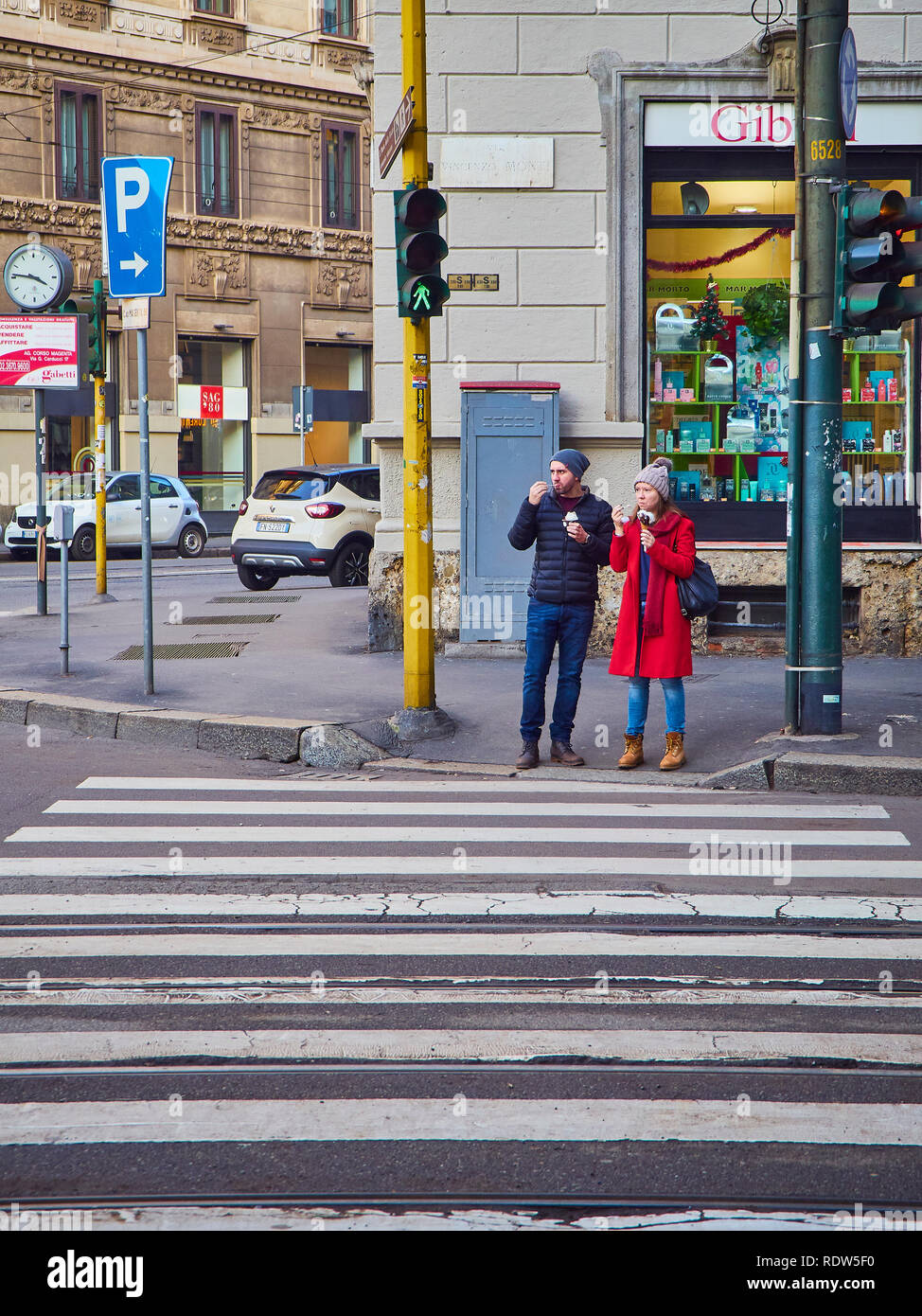 Ein paar Eis essen warten, um einen Zebrastreifen der Zona Magenta Viertel in der Innenstadt von Mailand, Lombardei, Italien zu überqueren. Stockfoto