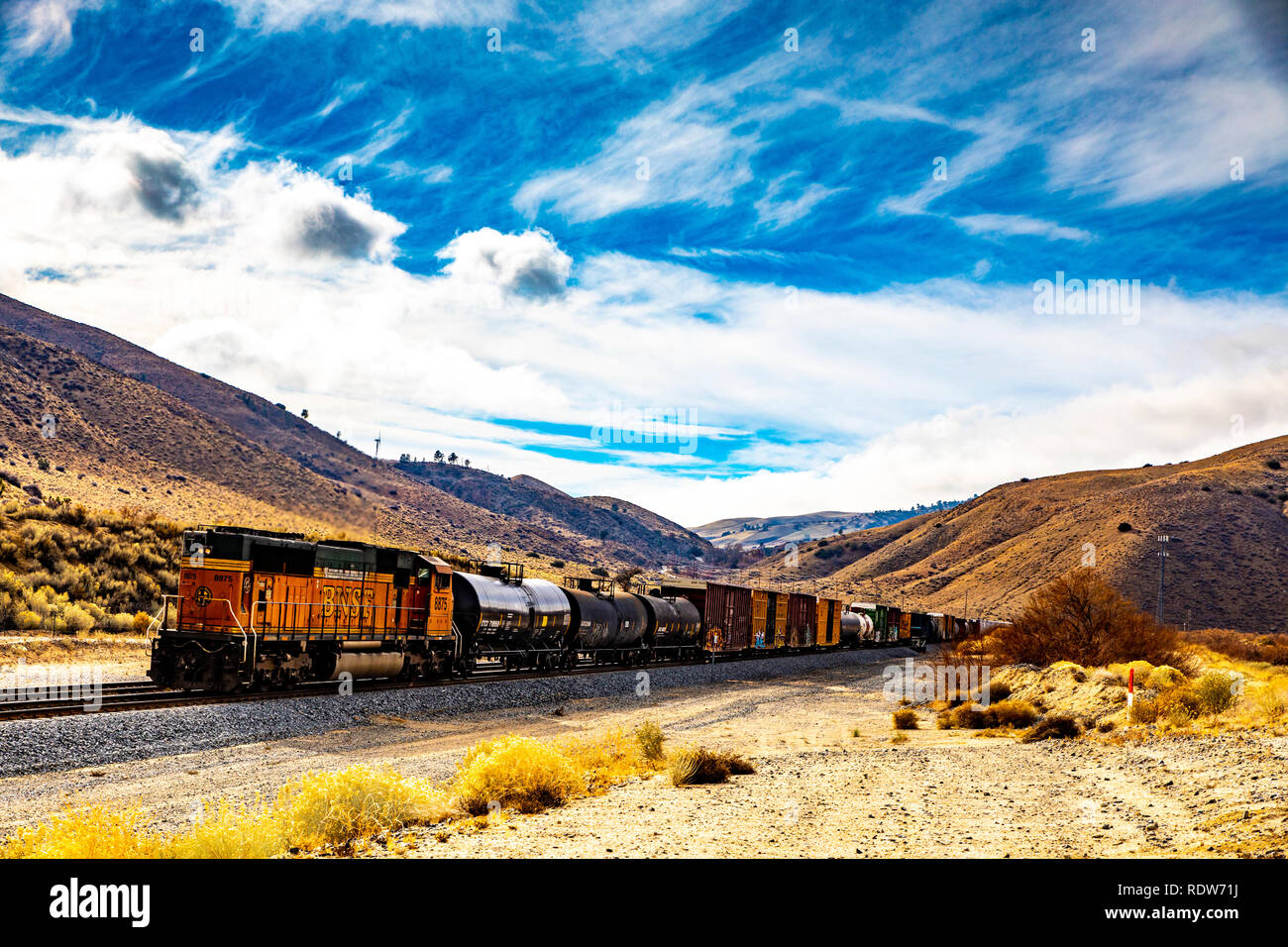 Ein BNSF Güterzug Richtung Westen in Richtung Tehachapi Kalifornien mit einem Drücker Lokomotive auf der Rückseite des Zug Stockfoto