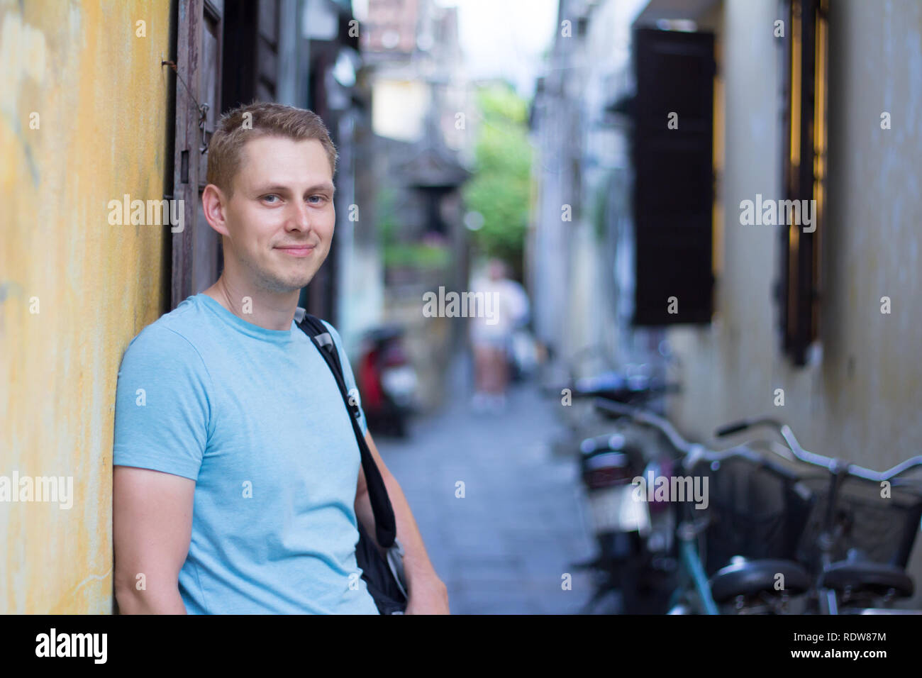 Mann Tourist in kausaler Kleidung posiert auf der Straße in engen Gasse Stockfoto