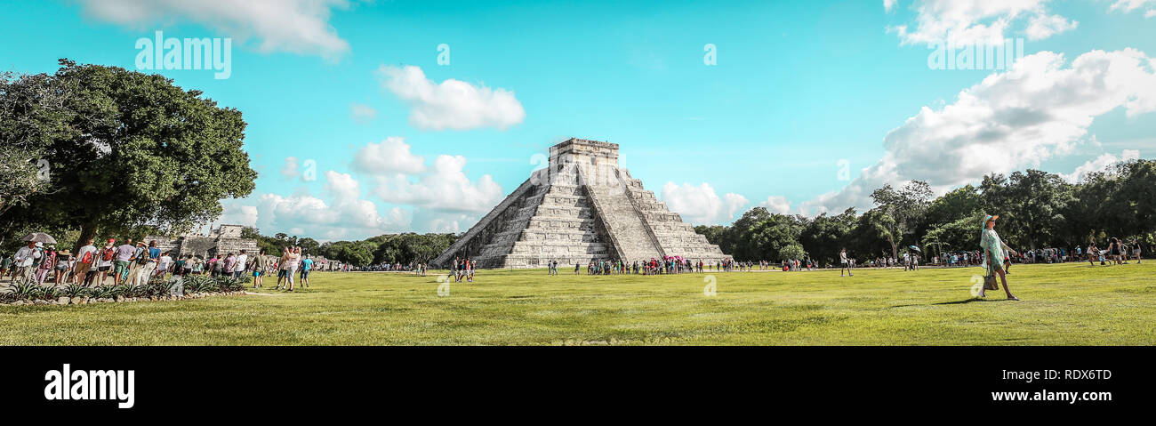 Chichen Itza Pyramide und elegante junge Frau zu Fuß in den Sonnenuntergang mit dramatischen bewölkte Himmel im Hintergrund Stockfoto