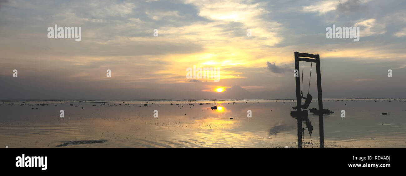 Junge Mädchen auf der Schaukel im schönen goldenen Sonnenuntergang in Asien Stockfoto