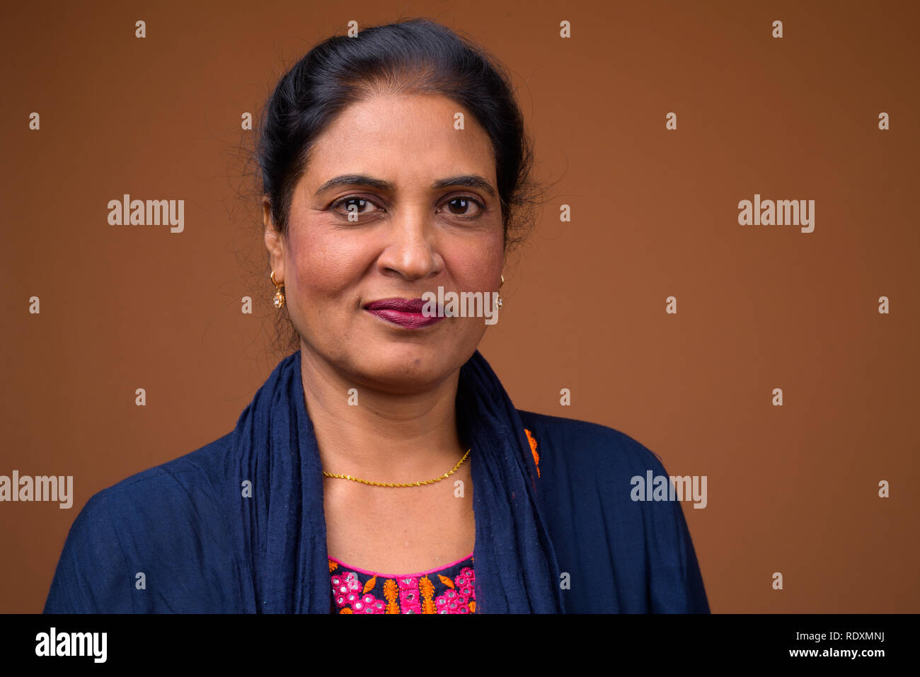 Angesichts der schönen indischen Frau gegen braunen Hintergrund Stockfoto