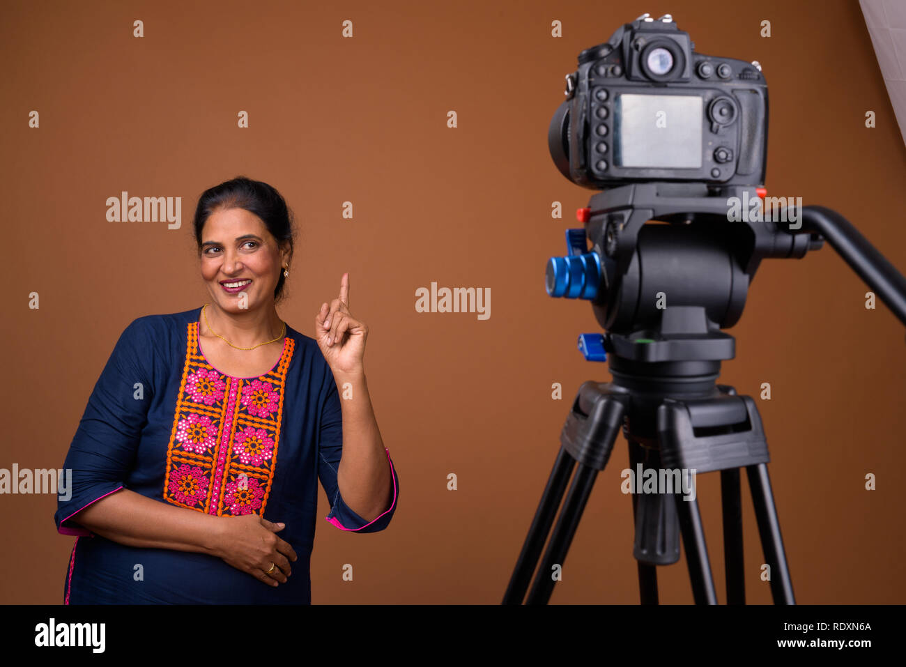Reifen schöne indische Frau vlogging im Studio mit Kamera Stockfoto