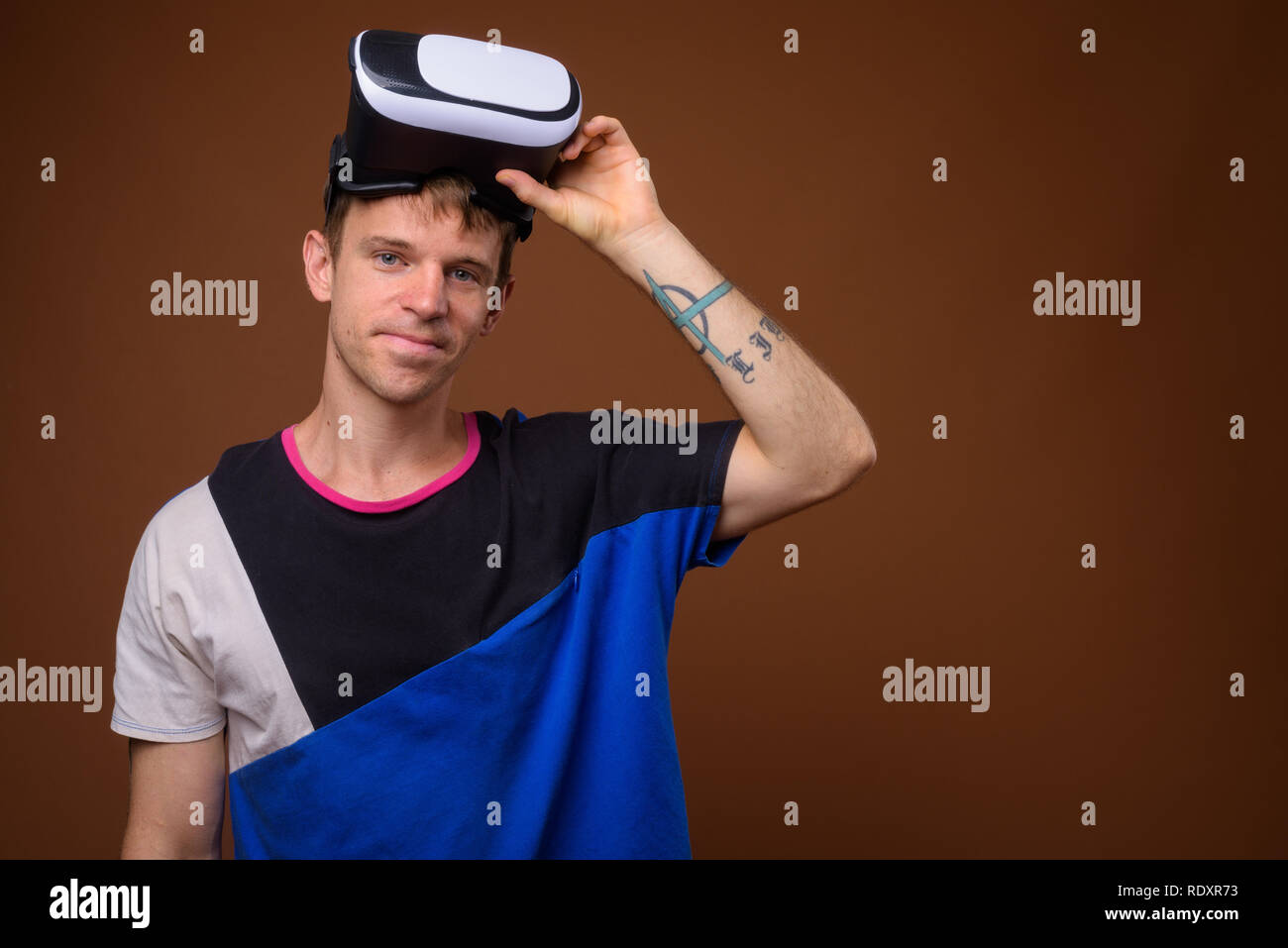 Mann mit Virtual reality Headset gegen braunen Hintergrund Stockfoto