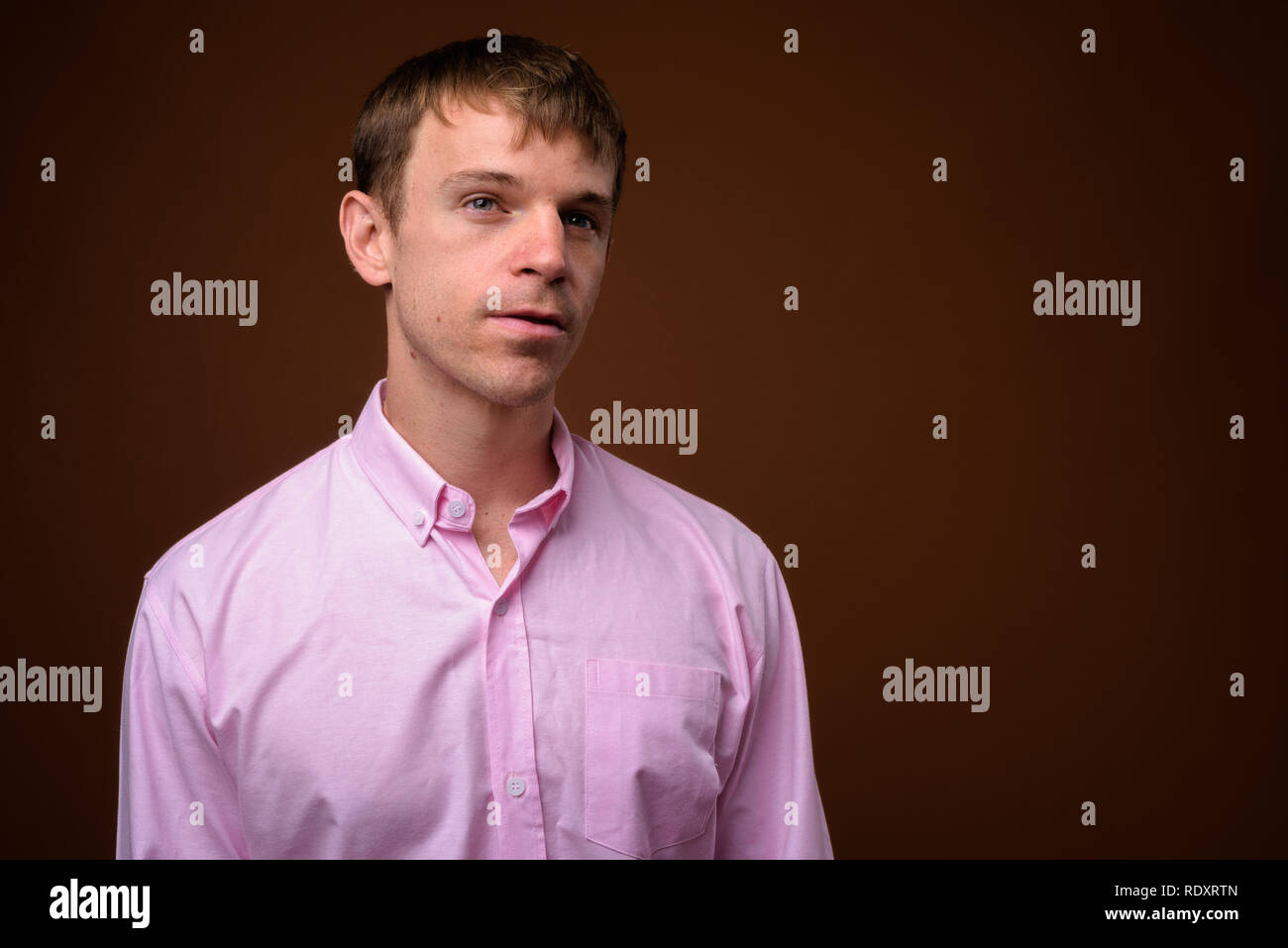 Unternehmer tragen rosa Shirt gegen braunen Hintergrund Stockfoto