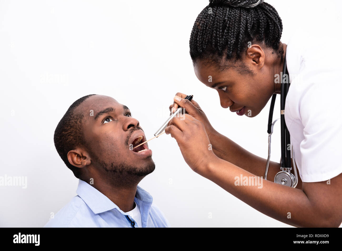 Ärztin der Mann Halsschmerzen mit Zungenspatel auf weißem Hintergrund Stockfoto