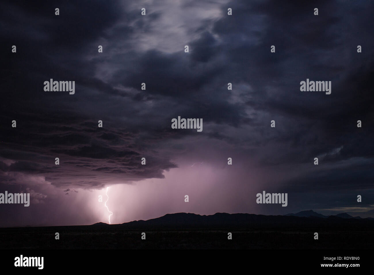 Stikes Blitzeinschlag in der Nähe einer kleinen Bergkette in die Chihuahuan Wüste im Süden von New Mexiko Stockfoto