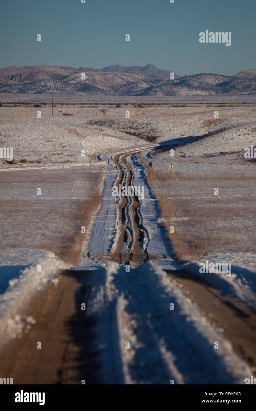 Spuren durch den Schnee in den Abstand auf einem Feldweg in der Entfernten bootheel Region New Mexico Stockfoto