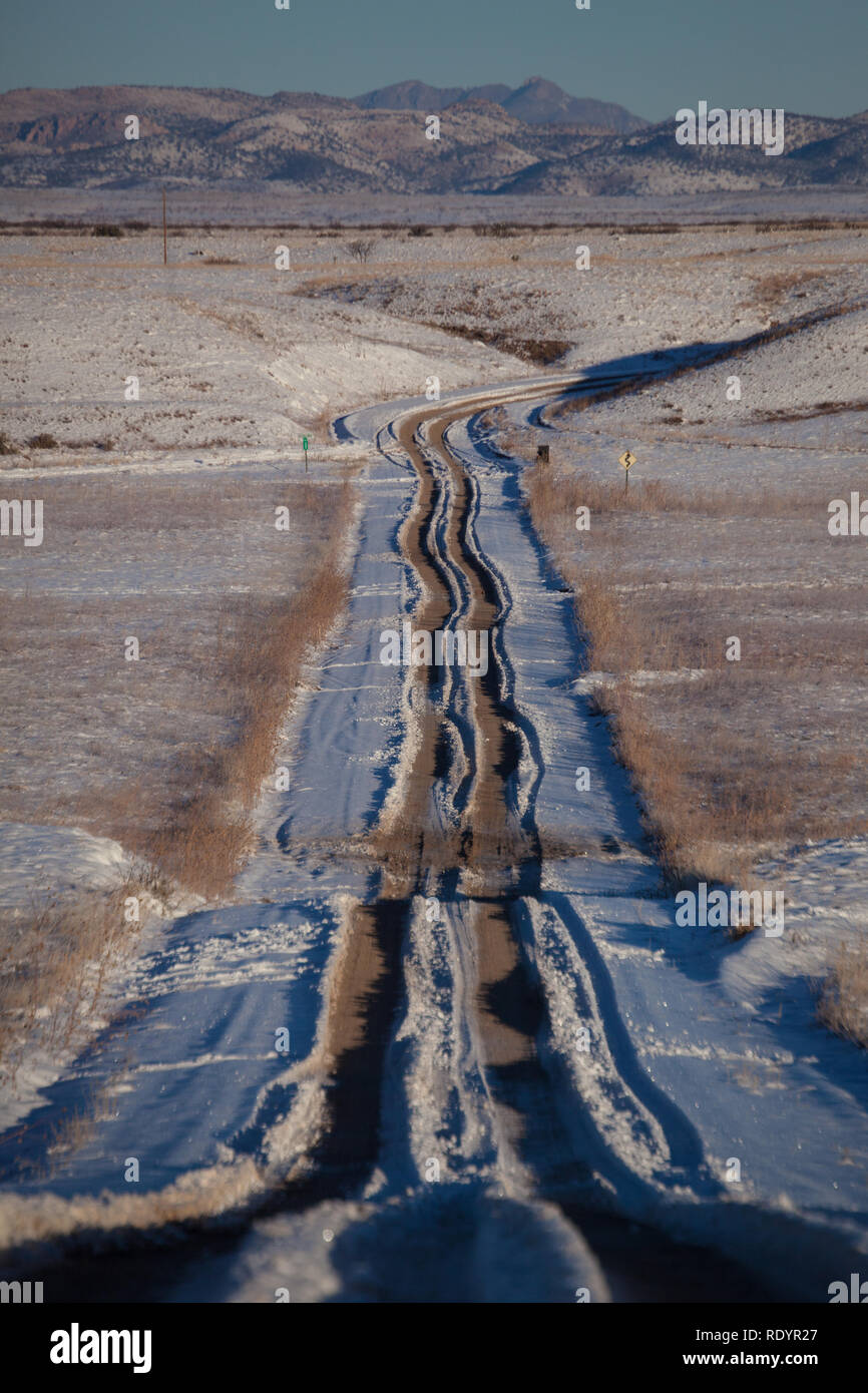 Spuren durch den Schnee in den Abstand auf einem Feldweg in der Entfernten bootheel Region New Mexico Stockfoto