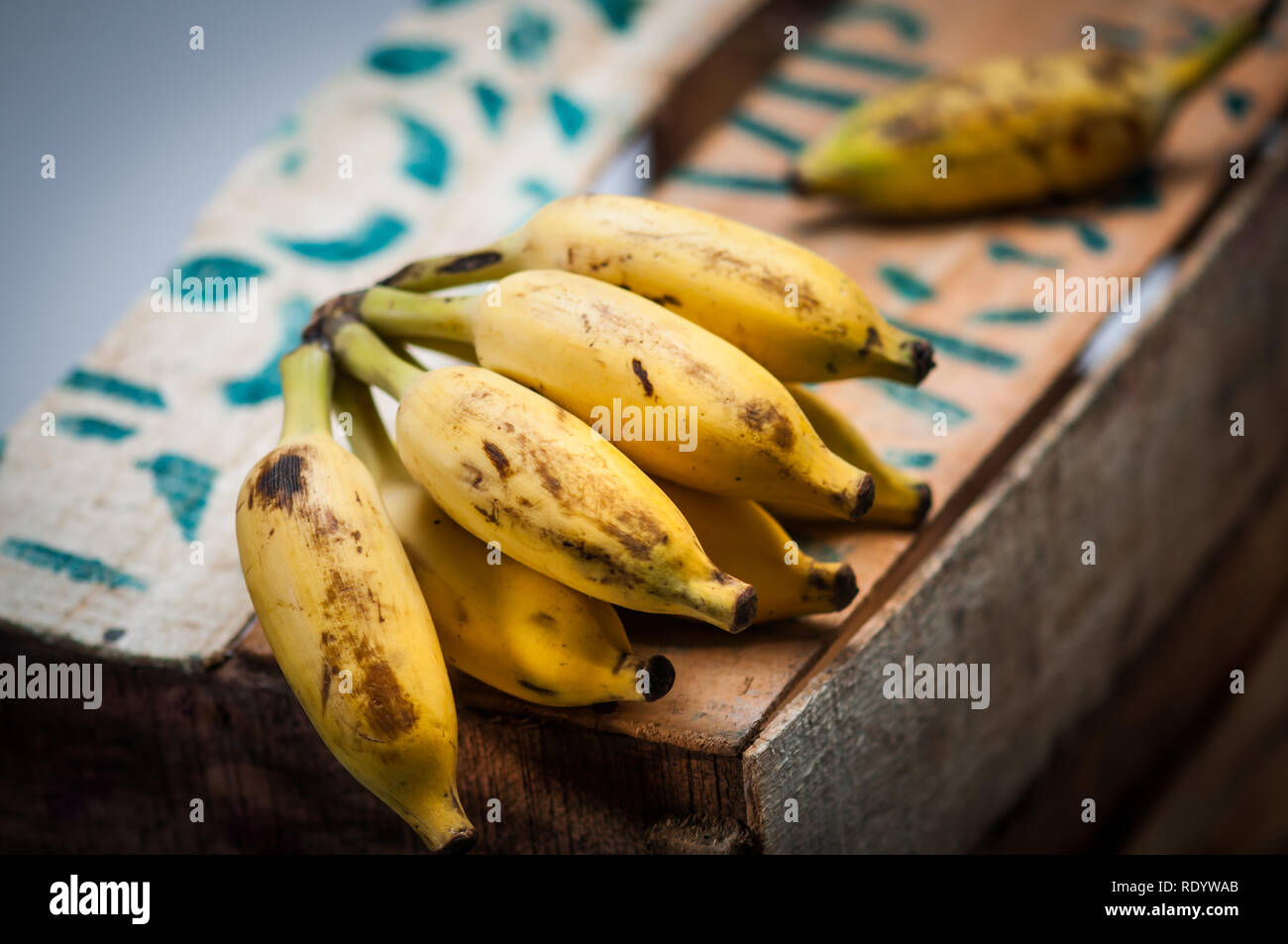 Bündel von Indischen kleine Bananen auf einer Holzkiste auf dem Markt angezeigt. Stockfoto