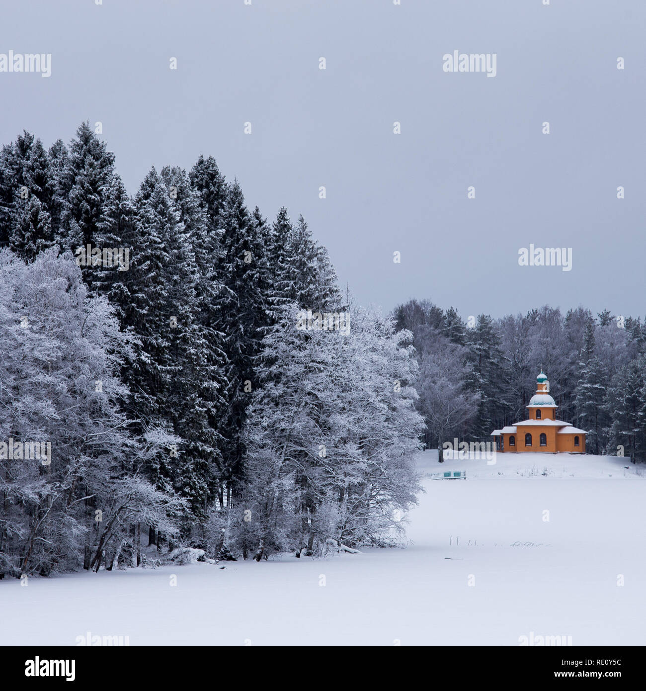 Schnee bedeckt Kapelle und Bäume im Winter Wald Stockfoto