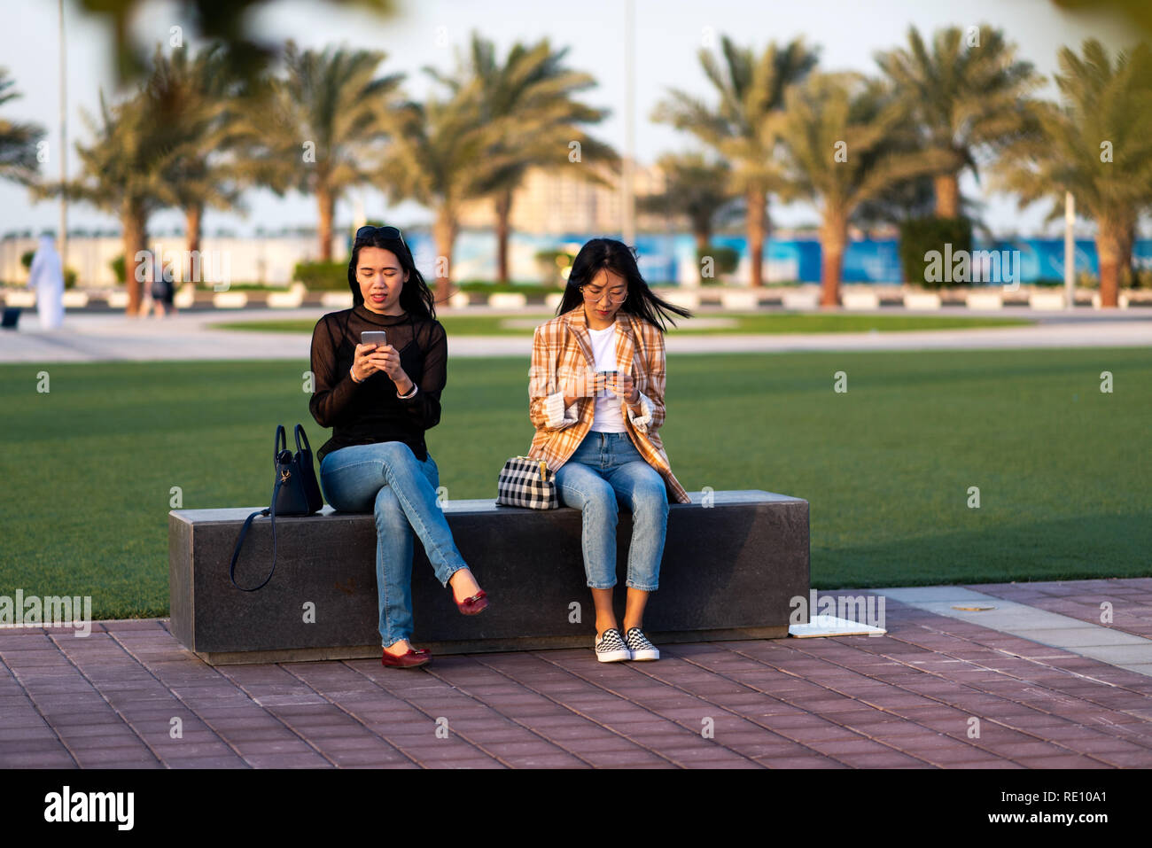 Zwei Mädchen aus Smartphones im Park Stockfoto