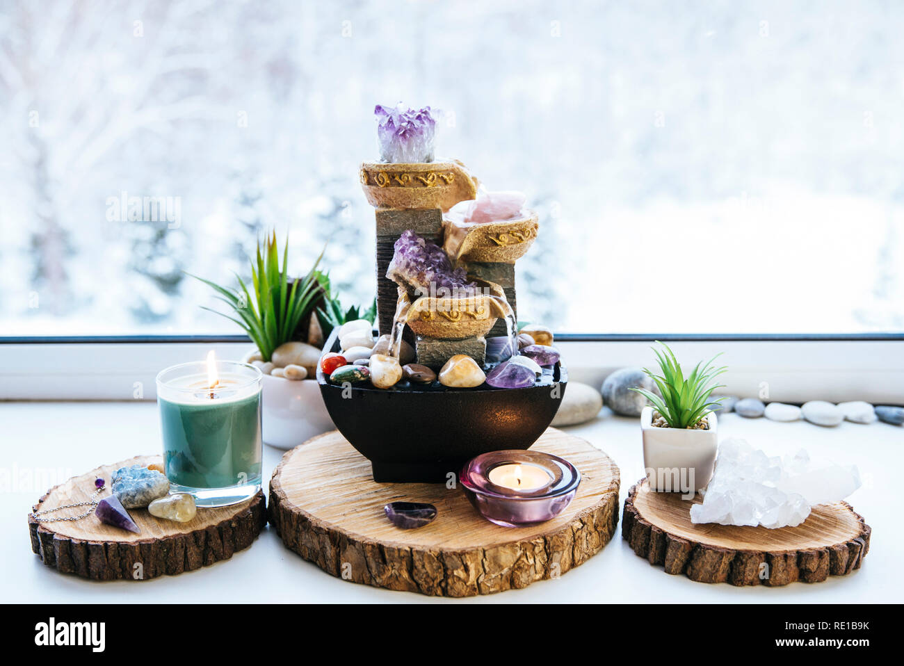 Entspannten, spirituellen Feng Shui Altar mit Natur, Wasser und Feuer Element festlegen. Tischplatte kleiner elektrischer Brunnen mit Wasser gießen Cups. Symbol des Reichtums. Stockfoto