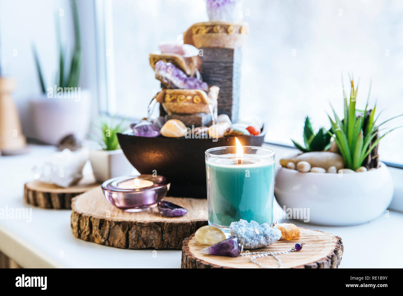 Entspannten, spirituellen Feng Shui Altar mit Natur, Wasser und Feuer Element festlegen. Tischplatte kleiner elektrischer Brunnen mit Wasser gießen Cups. Symbol des Reichtums. Stockfoto