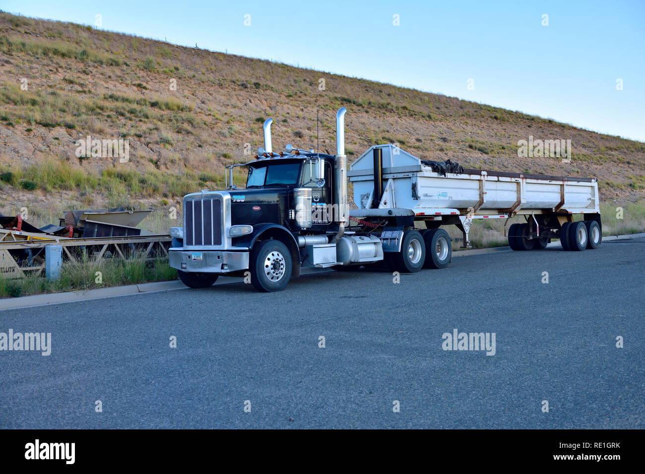 Große American Peterbilt Truck mit Anhänger für Sand oder Schotter Schleppen in der Nähe der Baustelle geparkt Stockfoto