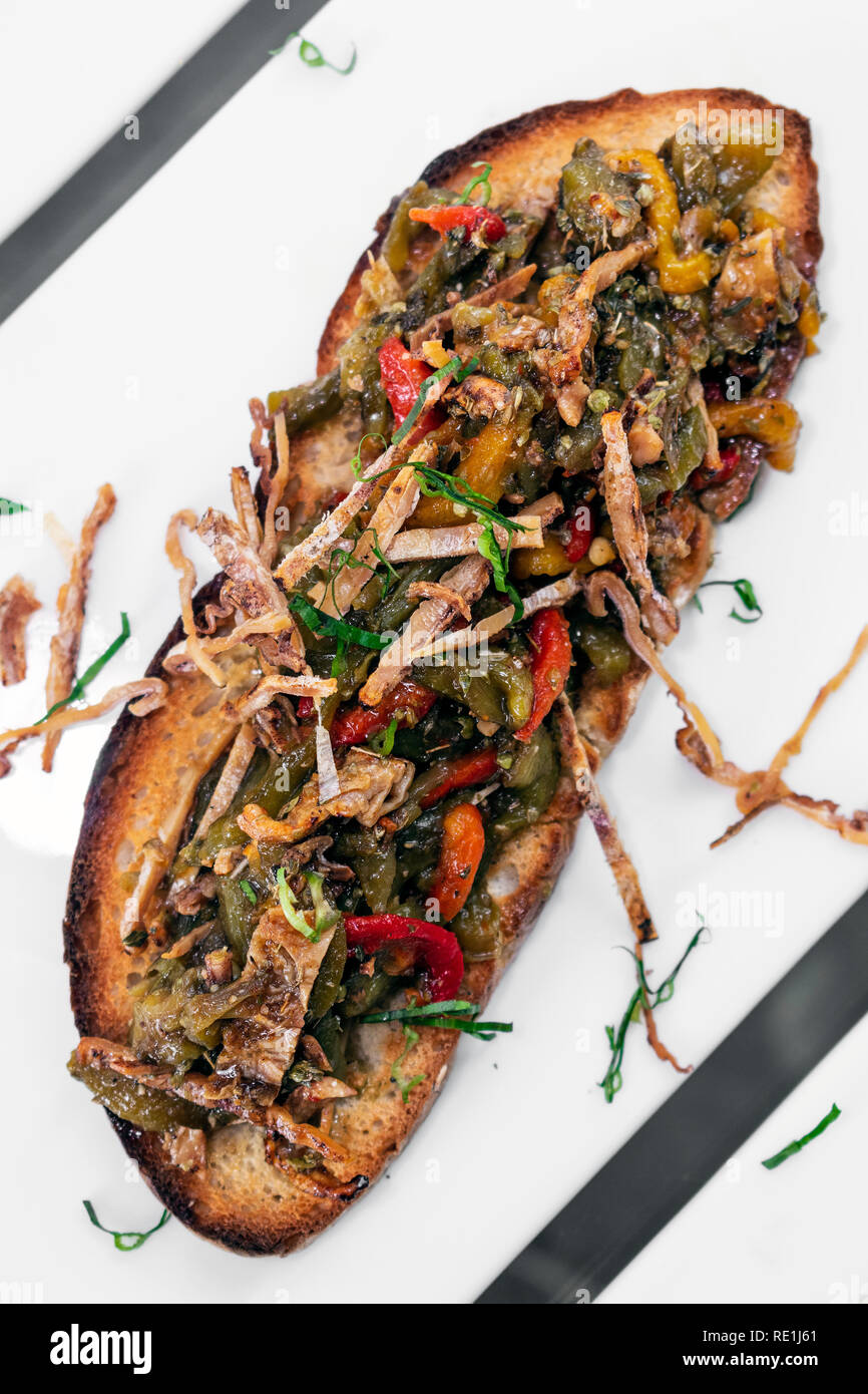 Würzigen getrockneten Tintenfisch und gebratenem Gemüse sandwich Tapas in Portugal getoastet Stockfoto
