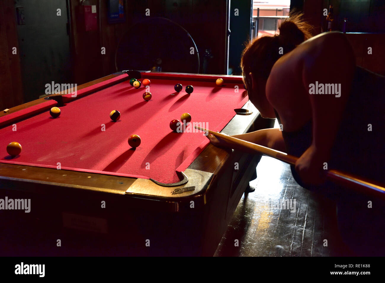 Junge Frau spielen Pool im Saloon Bar Stockfoto