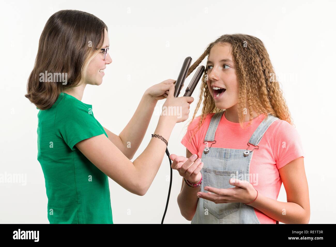 Portrait von zwei Jugendlichen Freundinnen Haarschnitt zuhause tun. Weißer Hintergrund. Stockfoto