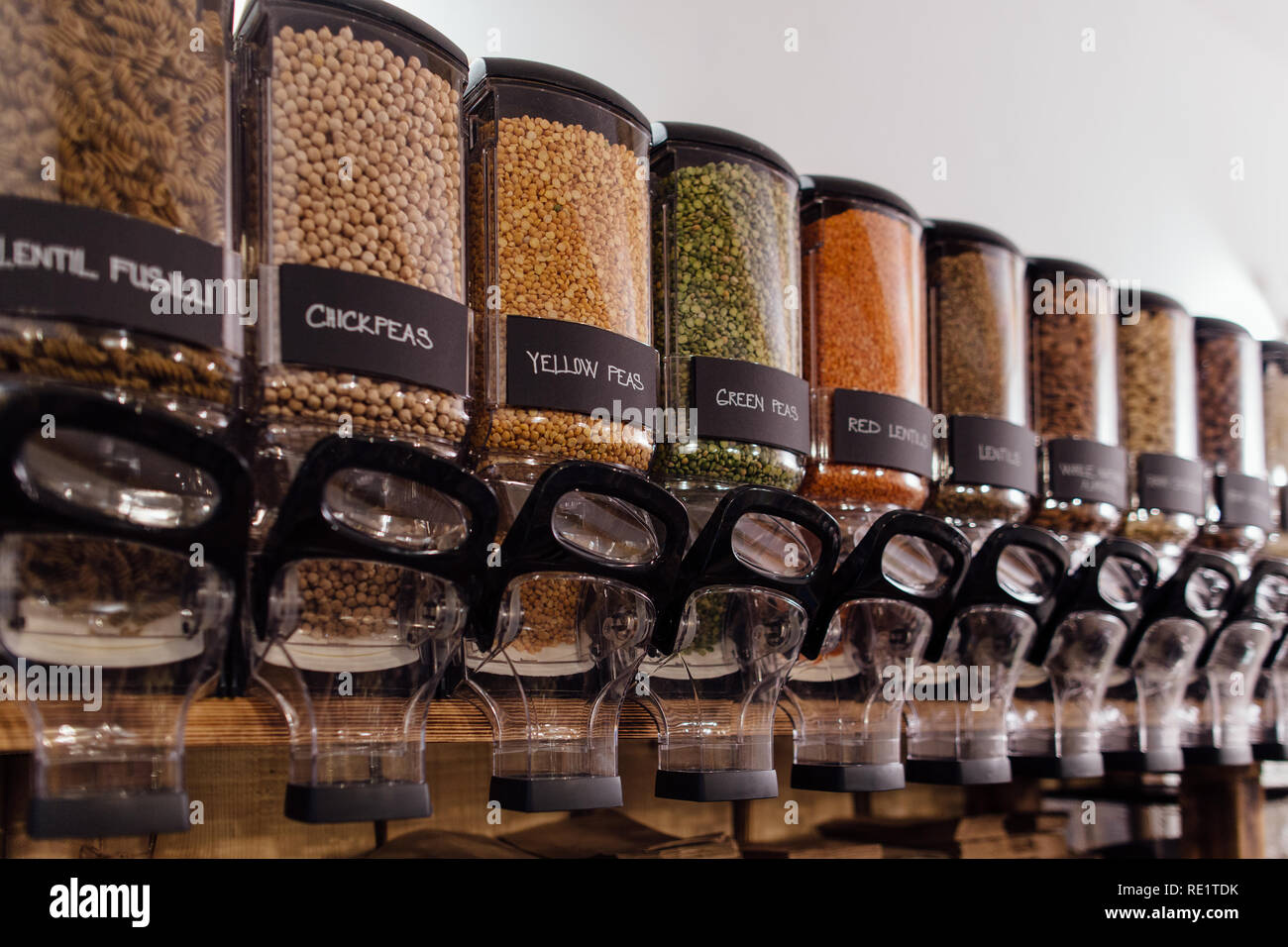 Seitenansicht von rohen Lebensmitteln in Lebensmittelgeschäft angezeigt. Lebensmittel Shop Interior - Regal mit Gläsern voller Erbsen und Linsen in organischen Shop. Stockfoto