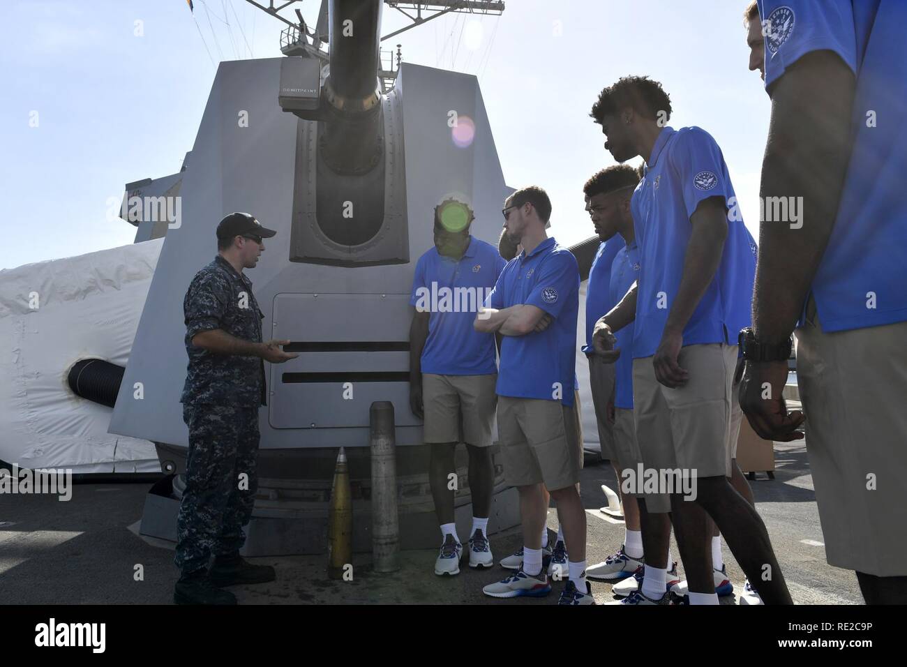 PEARL HARBOR (Nov. 9, 2016) Petty Officer 2nd class Kyle Stuart Vitrinen MK 45 5-Zoll-gun Munition Universität Basketball's Kansas Jayhawks Männer team Spieler während einer Schiffstour an Bord der geführte Anti-raketen-Zerstörer USS Chafee (DDG90) am Joint Base Pearl Harbor-Hickam. Die Tour war ein Teil der Streitkräfte 2016 ESPN Classic, die empfohlene NCAA Division I Herren Doppelspiel Basketball Spiele Arizona-wildkatzen gegen Michigan State Spartans und an der Universität von Indiana Hoosiers vs. der Universität Kansas Jayhawks. Stockfoto