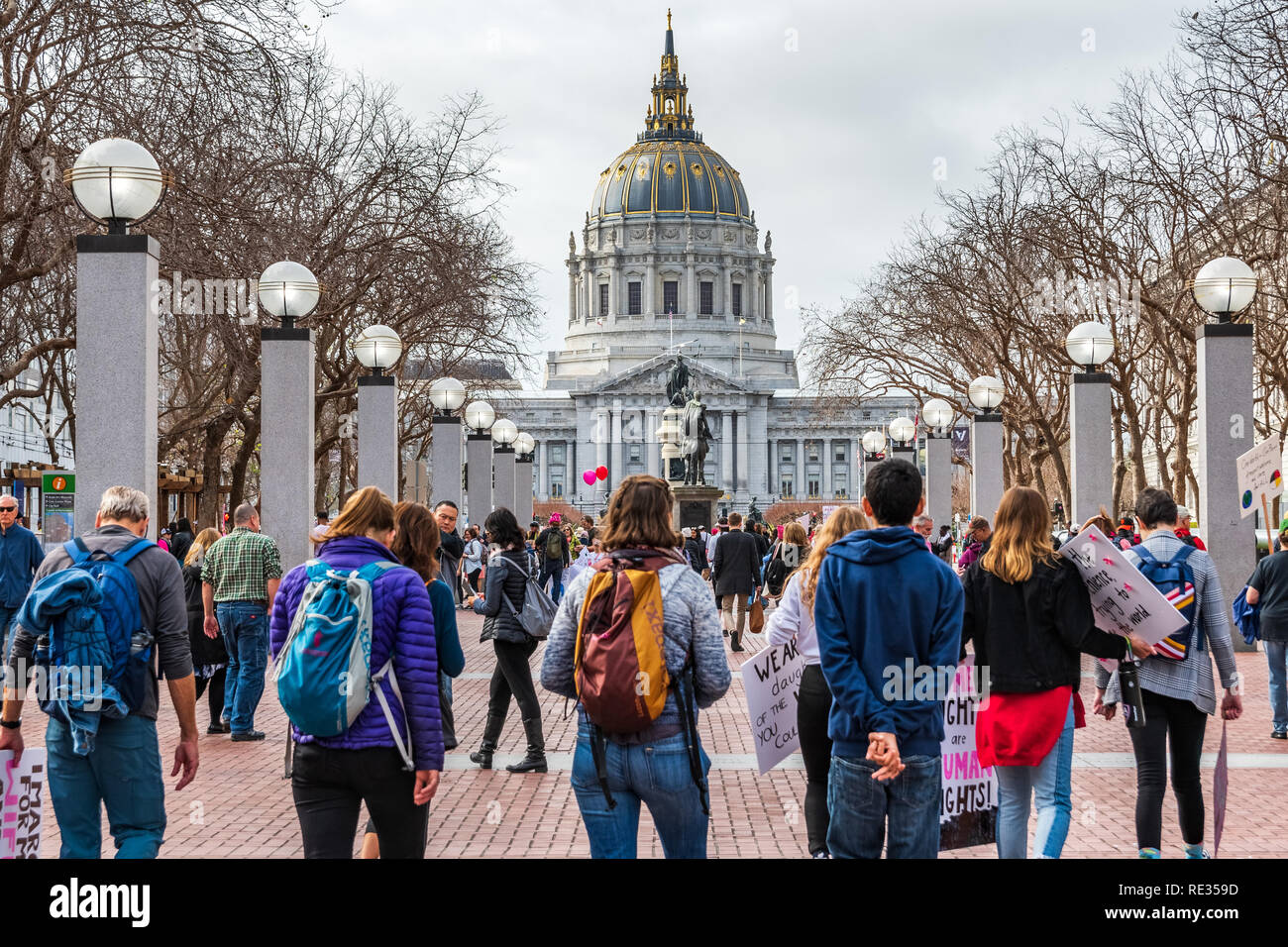 San Francisco, USA. 19. Jan 2019. Die Teilnehmer gehen bis März Rallye die Lage der Frauen, halten Schilder mit verschiedenen Nachrichten; das Rathaus Gebäude im Hintergrund sichtbar Stockfoto