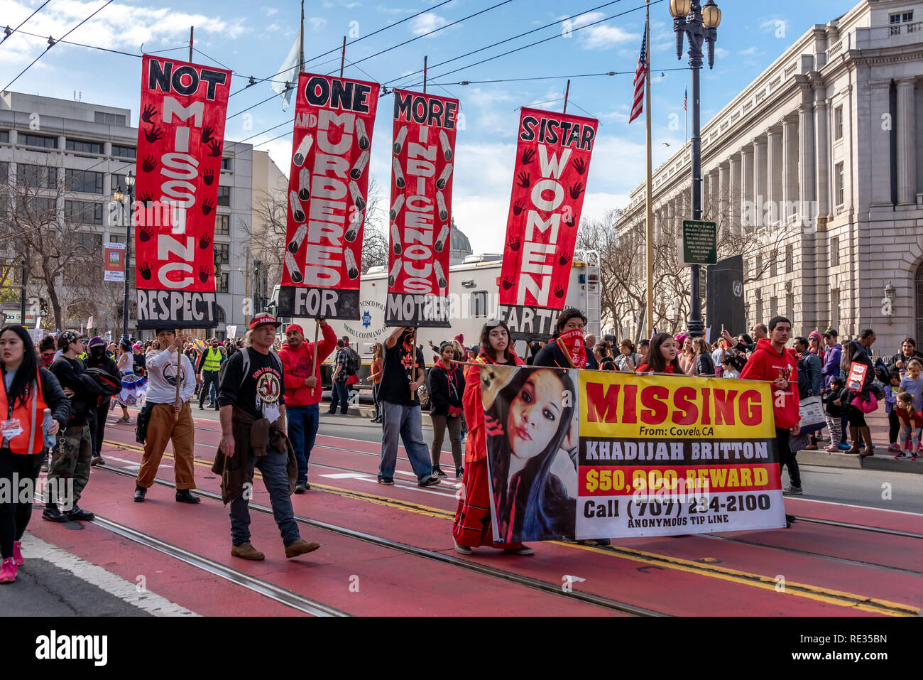 San Francisco, USA. 19. Januar, 2019. Der Frauen März San Francisco macht Weg nach unten die Market Street. Fehlende und ermordeten indigenen Frauen war ein prominenter Thema im März und Rallye. Hier eine Gruppe in rot gekleidet. März auf die Frage in Nordkalifornien zu bringen, durch die Fahne led für eine fehlende junge Frau aus Covelo, Kalifornien: khadijah Britton. Credit: Shelly Rivoli/Alamy leben Nachrichten Stockfoto