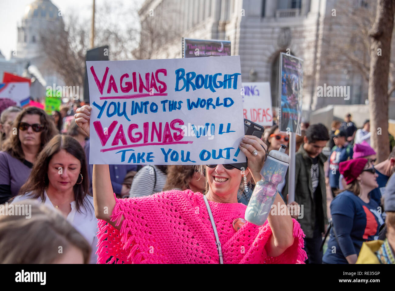 San Francisco, USA. 19. Januar, 2019. März San Francisco der Frauen, eine Frau in einem hellen Rosa poncho Lächeln, da sie hält ihre Zeichen lesen: "Vagina sie in diese Welt gebracht. Vaginas verlassen Sie!" Credit: Shelly Rivoli/Alamy leben Nachrichten Stockfoto