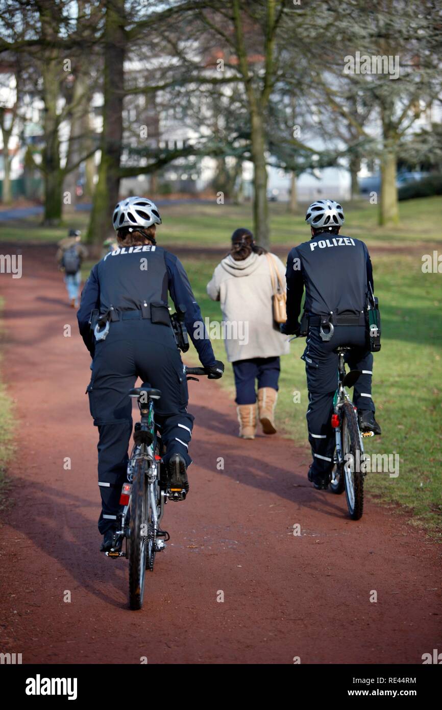 Fahrrad Polizei patrouilliert in einen städtischen Park Stockfoto