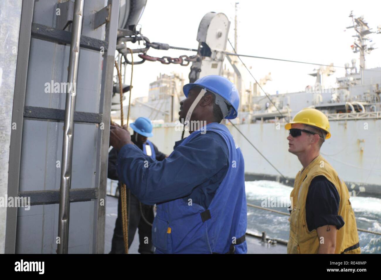 ARABIAN GULF (Nov. 23, 2016) Petty Officer 2nd class Matthew Fudge, Links, Rigs ein cargo Station an Bord der geführte-missile Cruiser USS San Jacinto (CG56) während einer Auffüllung-auf-See mit dem schnellen Combat support ship USNS Arktis (T-AOE-8). Fudge serviert an Bord der San Jacinto als bootsmann mate Schulung und Leitung Personal in der Wartung der Schiffe und Bewahrung. San Jacinto, eingesetzt als Teil von Eisenhower Carrier Strike Group, unterstützt Maritime Security Operations und Theater Sicherheit Zusammenarbeit in den USA 5 Flotte Bereich der Operationen. Stockfoto