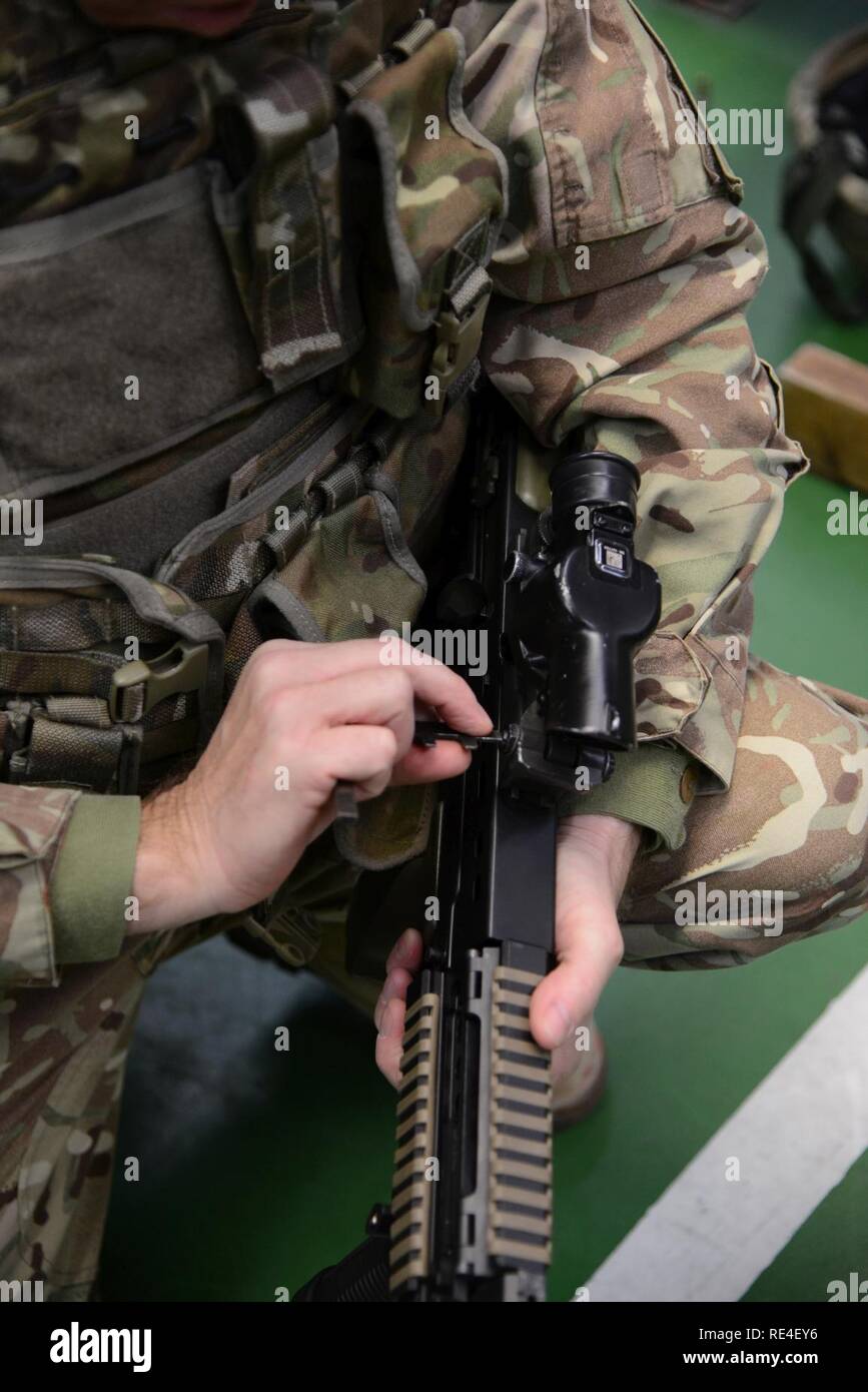 Mitglied der Britischen Streitkräfte, die zu den lokalen Einheiten zugeordnet, Nullen seine Waffe während der L 85 A2 rifle Kalibrierung bei der Schulung Support Center Benelux 25 m Reichweite im Innenbereich, in Chièvres Air Base, Belgien, November 30, 2016. Die britischen Truppen unter Aufsicht der britischen Joint European Training Team geschult Stockfoto