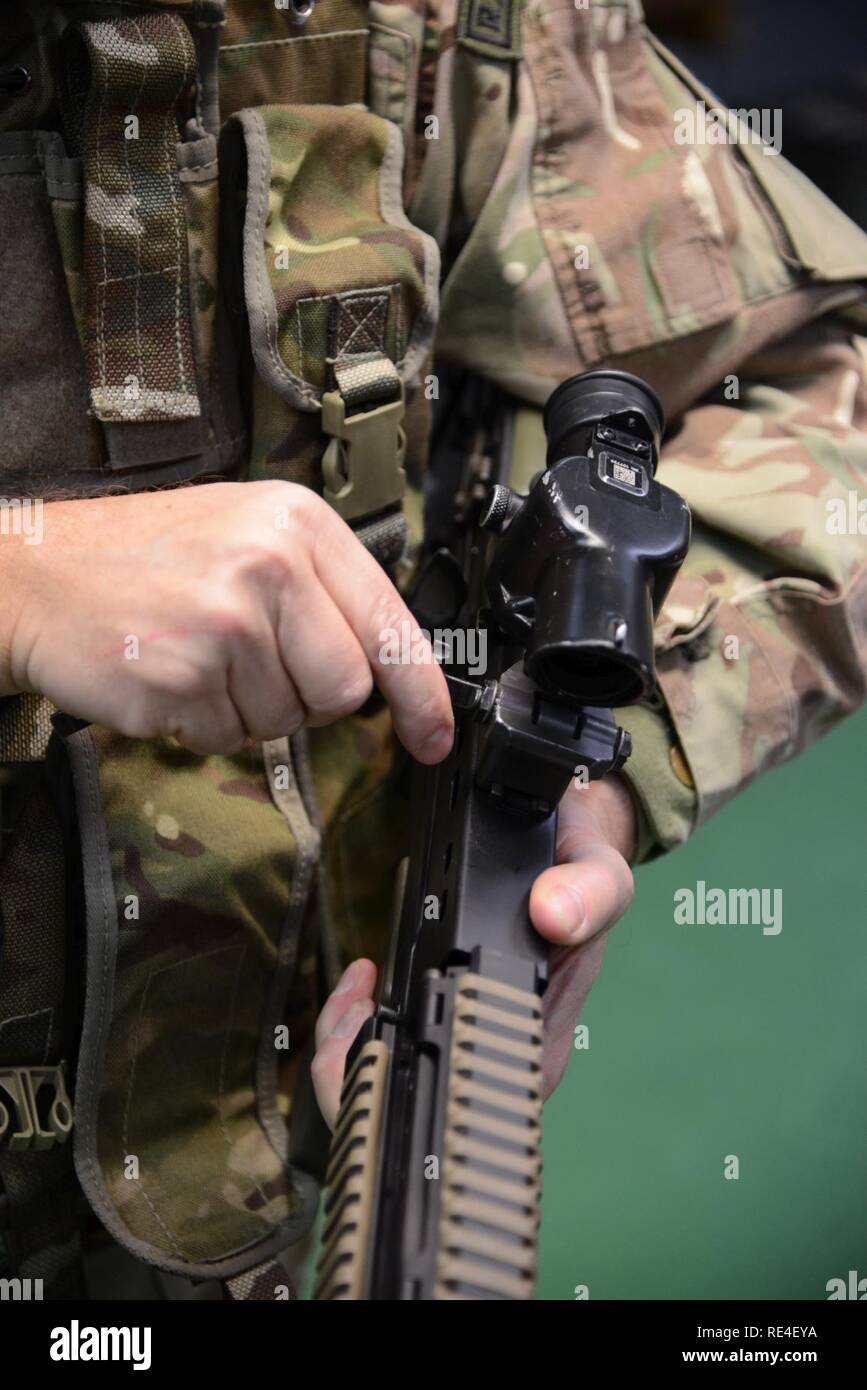 Mitglied der Britischen Streitkräfte, die zu den lokalen Einheiten zugeordnet, Nullen seine Waffe während der L 85 A2 rifle Kalibrierung bei der Schulung Support Center Benelux 25 m Reichweite im Innenbereich, in Chièvres Air Base, Belgien, November 30, 2016. Die britischen Truppen unter Aufsicht der britischen Joint European Training Team geschult Stockfoto
