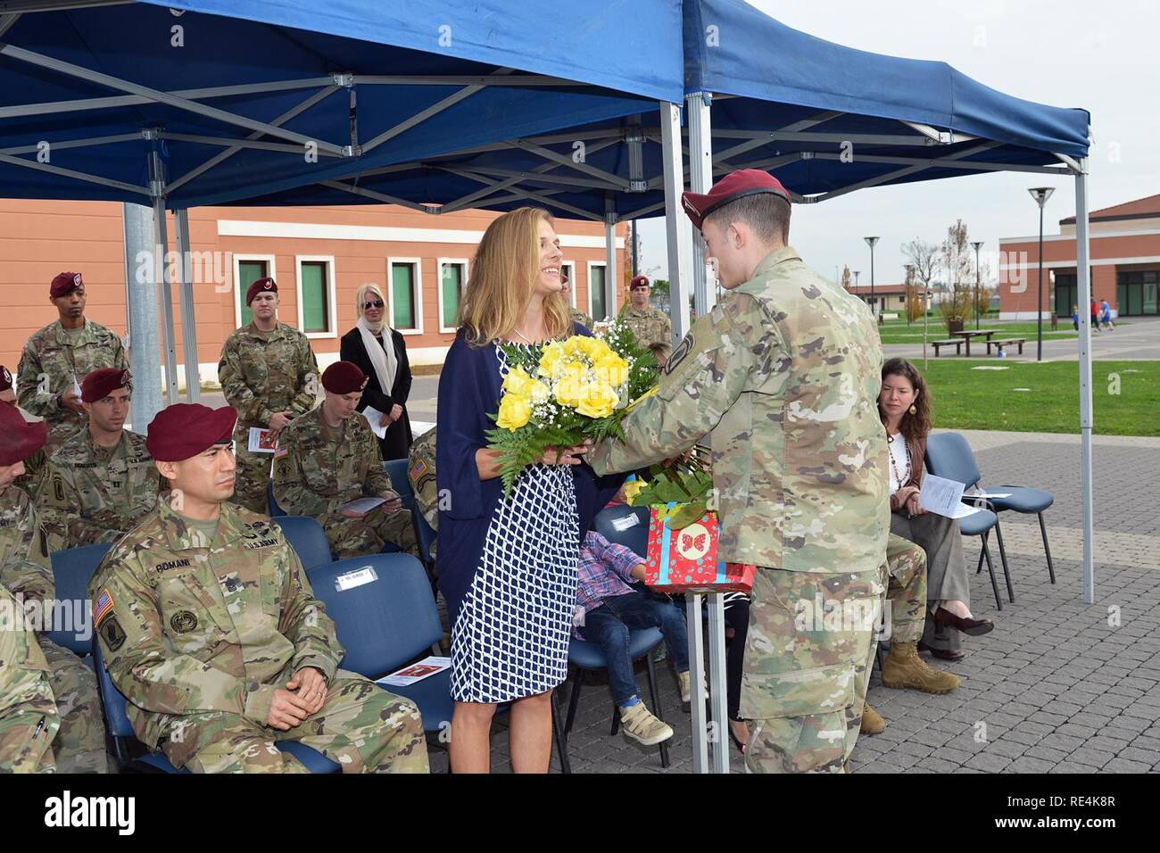 Frau von eingehenden Befehl Sgt. Maj. Delfin J. Romani erhält einen Strauß gelber Rosen von SPC. Edward Pooley, während der Übergang der Verantwortung Zeremonie für 54th Brigade Ingenieur Bataillon an Caserma Del Din in Vicenza, Italien, November 23, 2016. Die 173Rd Airborne Brigade in Vicenza, Italien, ist die Armee Contingency Response Force in Europa, und ist in der Lage, Kräfte projizieren die vollständige Palette von militärischen Operationen über den Vereinigten Staat in Europa, Zentral- und Südafrika Befehle Verantwortungsbereiche zu führen. Stockfoto