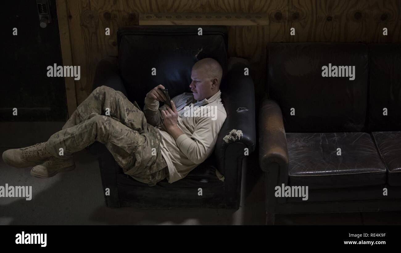 Staff Sgt. Ethan Kammern, 455Th Expeditionary Bauingenieur Squadron Bürgersteige und Ausrüstung, blättert durch Social Media auf Thanksgiving, November 24, 2016 am Flughafen Bagram, Afghanistan. Viele service Mitglieder social media mit Familie und Freunden in Kontakt zu bleiben, während sie im Einsatz, vor allem während der Ferien. Stockfoto