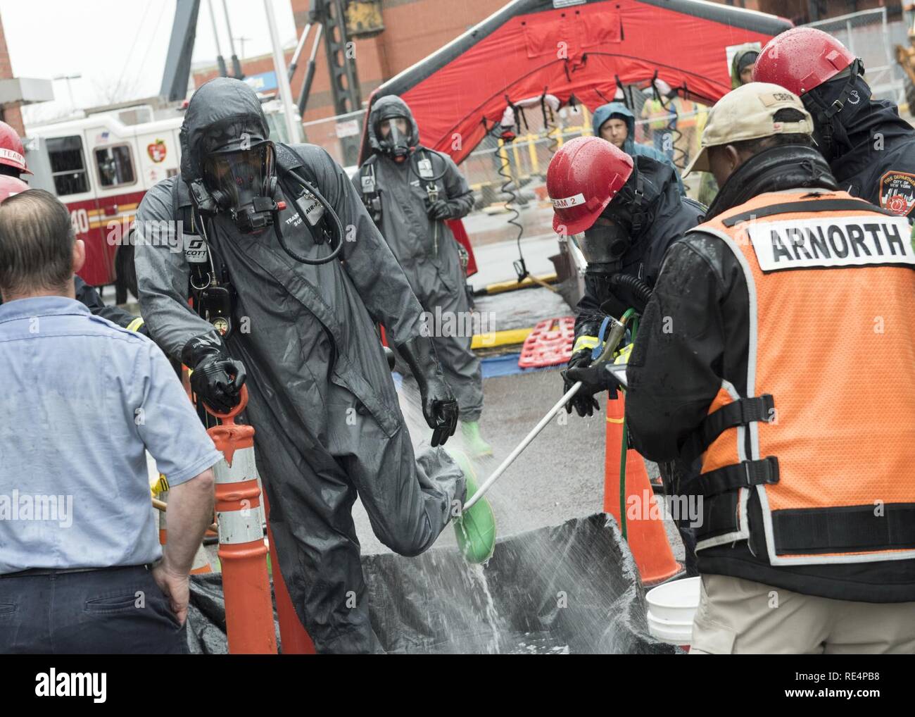 Die Mitglieder der New Yorker Feuerwehr Gefahrgut Team durchführen Dekontaminierungsverfahren auf US-Soldaten von Ft. Der Drum 59 CBRN-Unternehmen nach einer gemeinsamen Ausbildung Evolution in New York City, Nov. 29, 2016. Diese Veranstaltung war Teil einer Woche Training, organisiert von der Stadt New York und der US-Armee nach Norden, und durch US Northern Command überwacht. Die Ereignisse haben Soldaten und lokalen Ersthelfer die Freude an der Zusammenarbeit in einem komplexen chemischen, biologischen, radiologischen oder nuklearen Notfall. Stockfoto