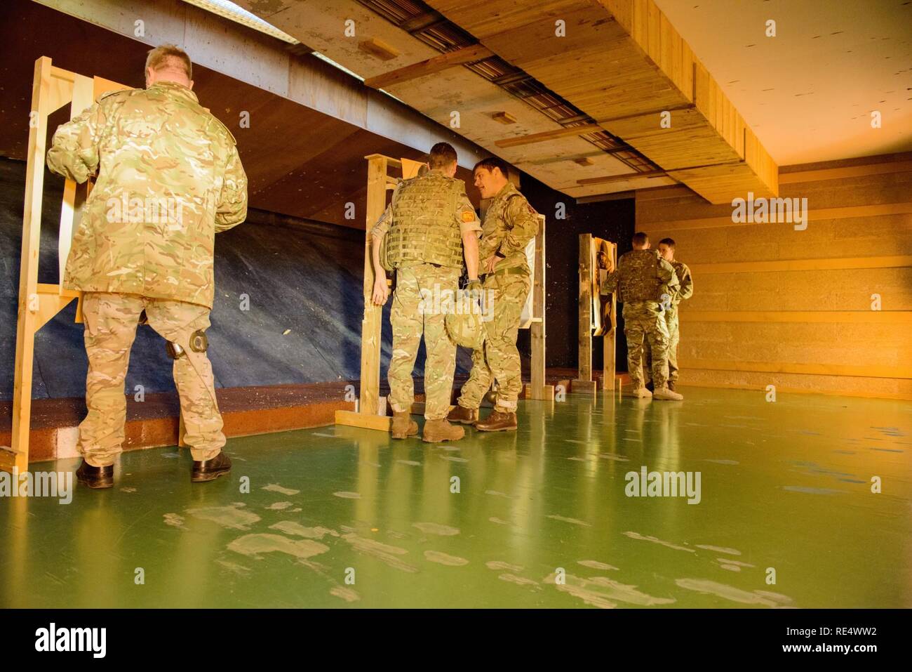 Mitglieder der Britischen Streitkräfte zugeordnet zu den lokalen Einheiten ihre Nullstellen Zielvorgaben nach dem Schießen mit ihren L 85 A2 Gewehren auf die Schulung Support Center Benelux 25 m Reichweite im Innenbereich, auf chièvres Air Base, Belgien, November 30, 2016 überprüfen. Die britischen Truppen unter Aufsicht der britischen Joint European Training Team ausgebildet. Stockfoto