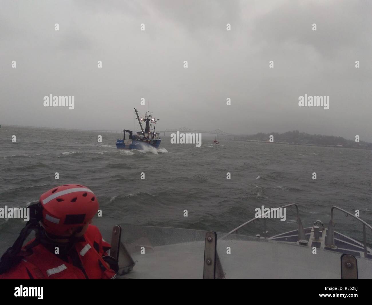 Eine Crew an Bord der Triumph II, ein 52-Fuß-Motor Leben Boot von der Coast Guard Station Cape Enttäuschung, schleppt die kommerzielle Fischereifahrzeug Lisa Marie auf dem Columbia River Bar, Jan. 3, 2019. Die Crew an Bord des Fischereifahrzeugs Verlust der Lenkung 17 Meilen weg von der Bar, und wurden sicher zum Astoria Kraftstoff Pier nach durch Coast Guard Besatzungen für 14 Stunden geschleppt wird. Us-Küstenwache Stockfoto