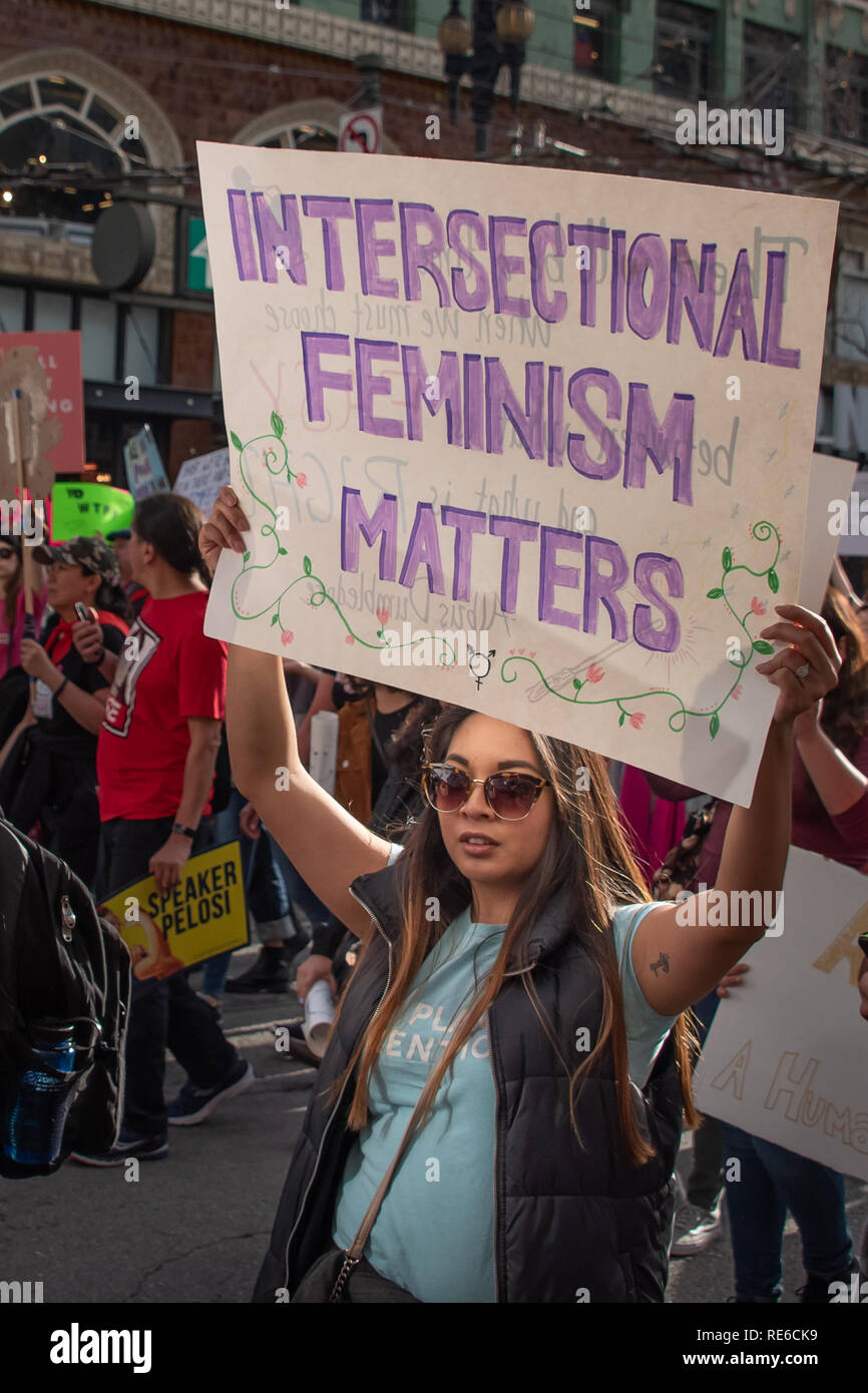 San Francisco, USA. 19. Januar, 2019. Eine junge Frau von Farbe trägt ein Schild mit der Aufschrift 'intersektionale Feminismus Fragen, 'im März San Francisco bei den Frauen. Credit: Shelly Rivoli/Alamy leben Nachrichten Stockfoto