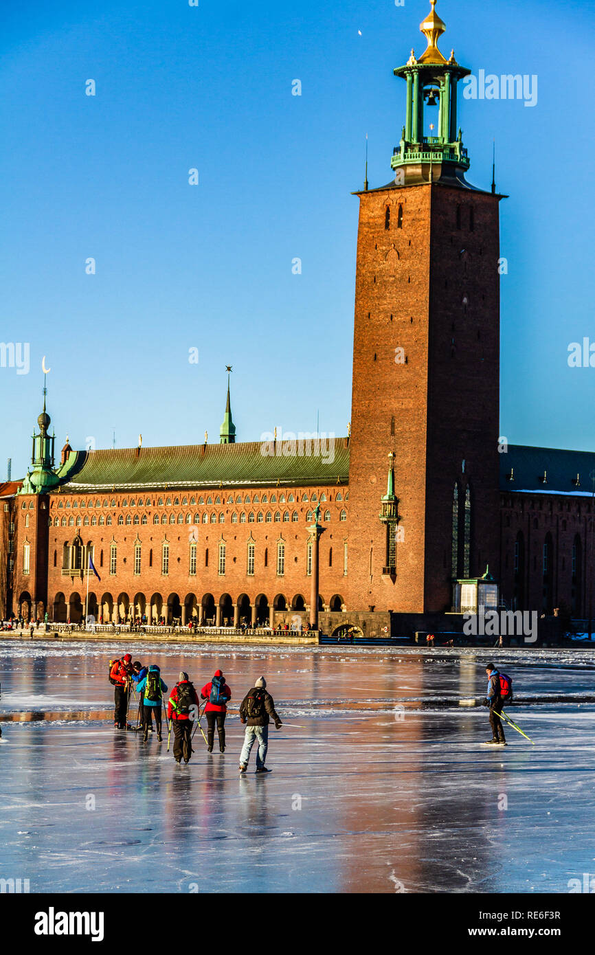 Schlittschuhläufer und Spaziergänger auf dem zugefrorenen See Malaren vor der City Hall, Stockholm, Schweden, an einem sonnigen Sonntag. 20. Januar, 2019. Stockfoto