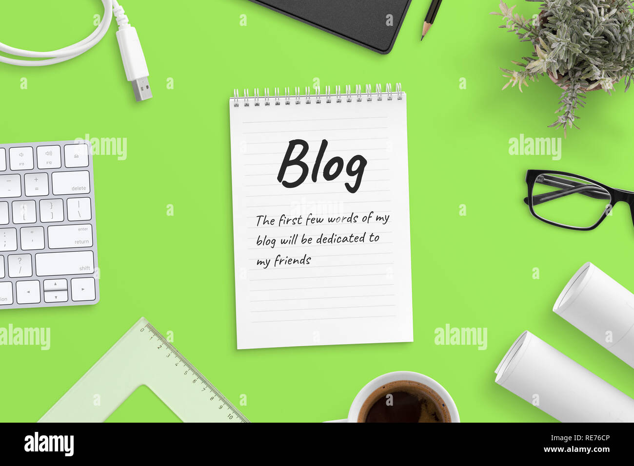 Blog Text in Notepad mit Bürobedarf umgeben. Grüner Hintergrund, Ansicht von oben, Held, Header Image. Stockfoto