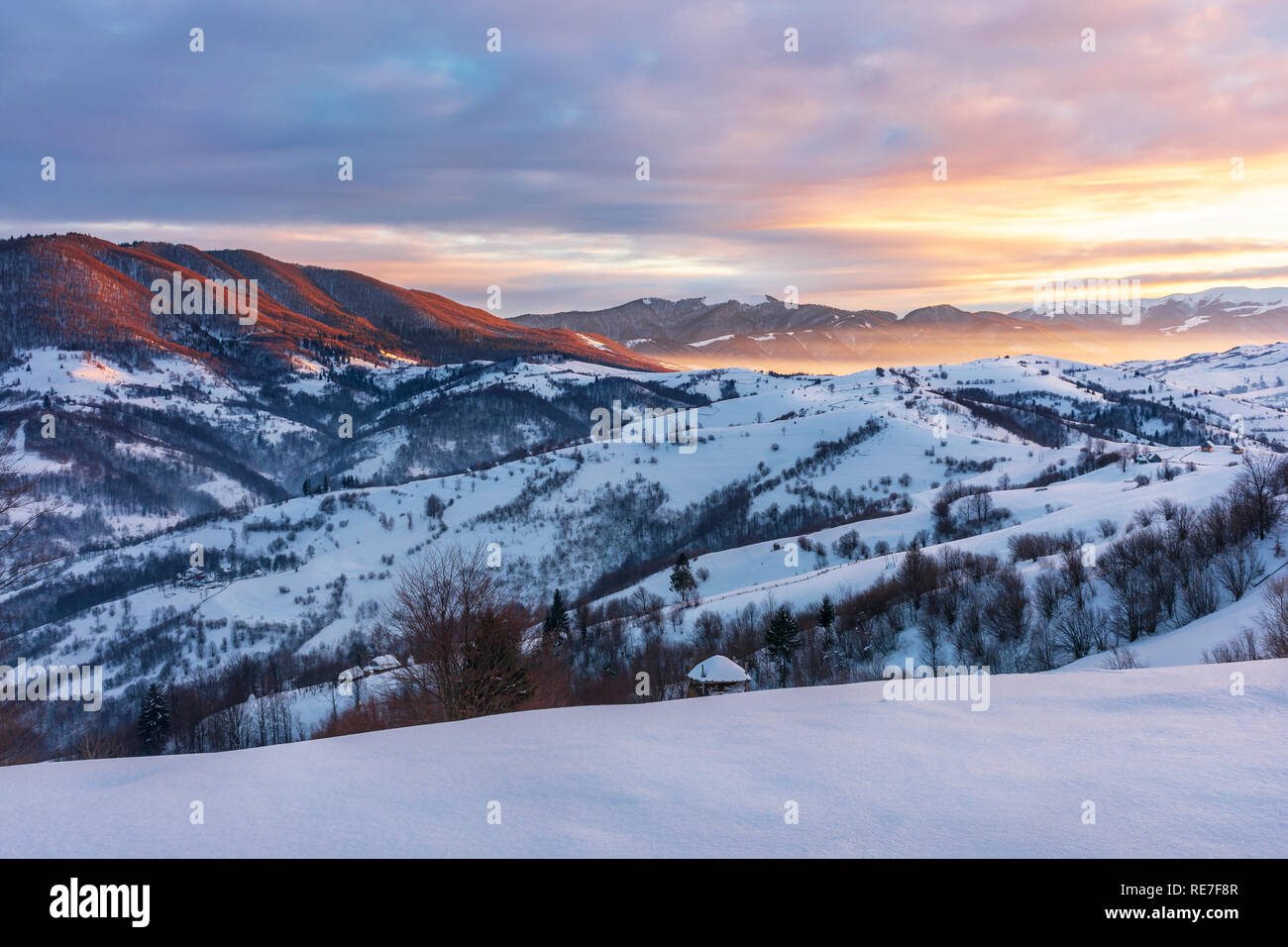 Winter Sonnenaufgang in den Bergen. schöne Landschaft der Karpaten. Der Himmel Brennt. ländlichen Gebiet mit sanften Hügeln. Guten Morgen wunderbare Welt Stockfoto