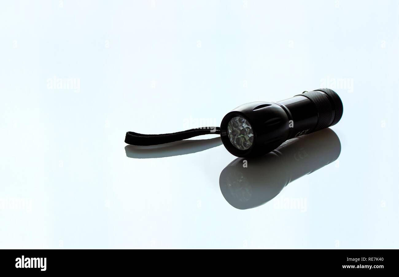 Hand Black Metal Taschenlampe auf hellen Hintergrund isoliert Stockfoto