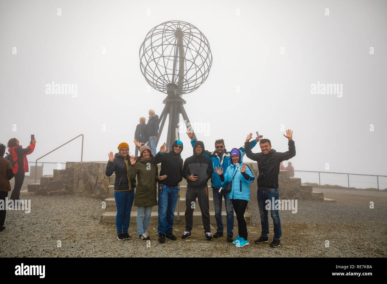 Nordkap, Norwegen - 26.06.2018: Gruppe von Touristen kommen zu den berühmten nordkap und liebe Fotos mit den ikonischen Globus Skulptur zu nehmen, auch auf einem sehr nebligen Tag mit schlechter Sicht, Norwegen Stockfoto