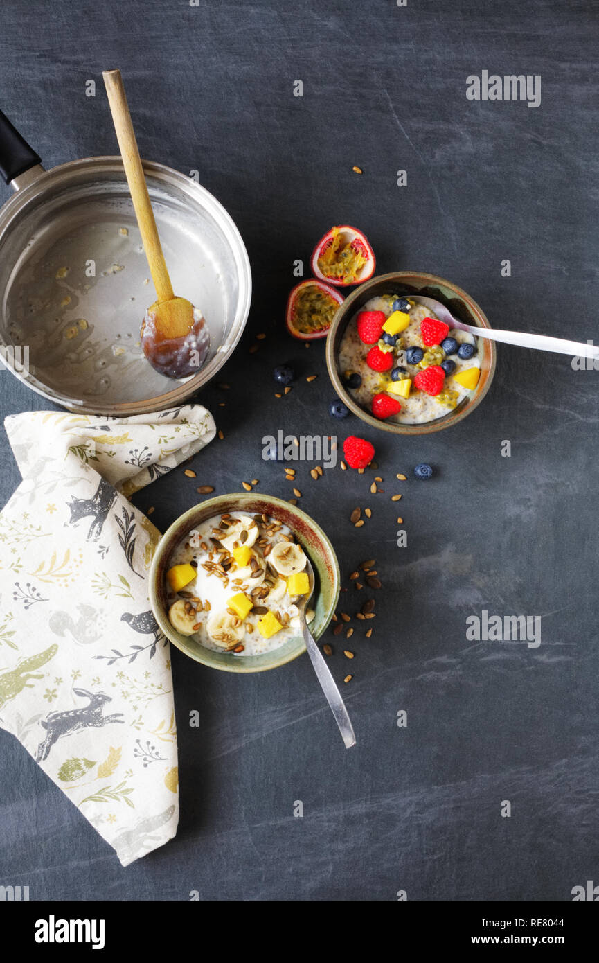 Ein gesundes Frühstück. Porridge mit Banane, Blaubeeren, Himbeeren, Passionsfrucht, Mango und Samen. Stockfoto