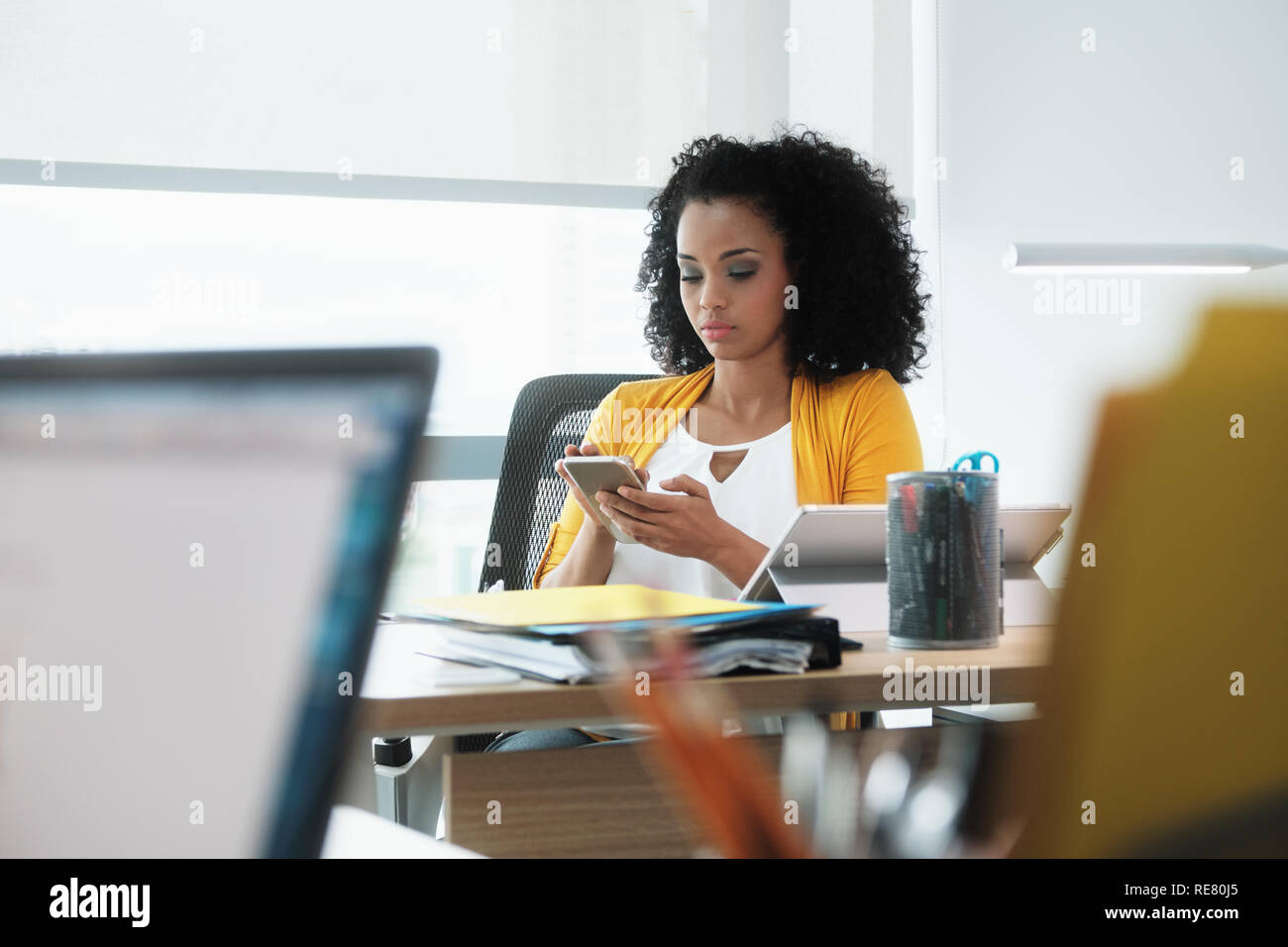 Schöne junge Business Frau mit Handy in Corporate Office Stockfoto