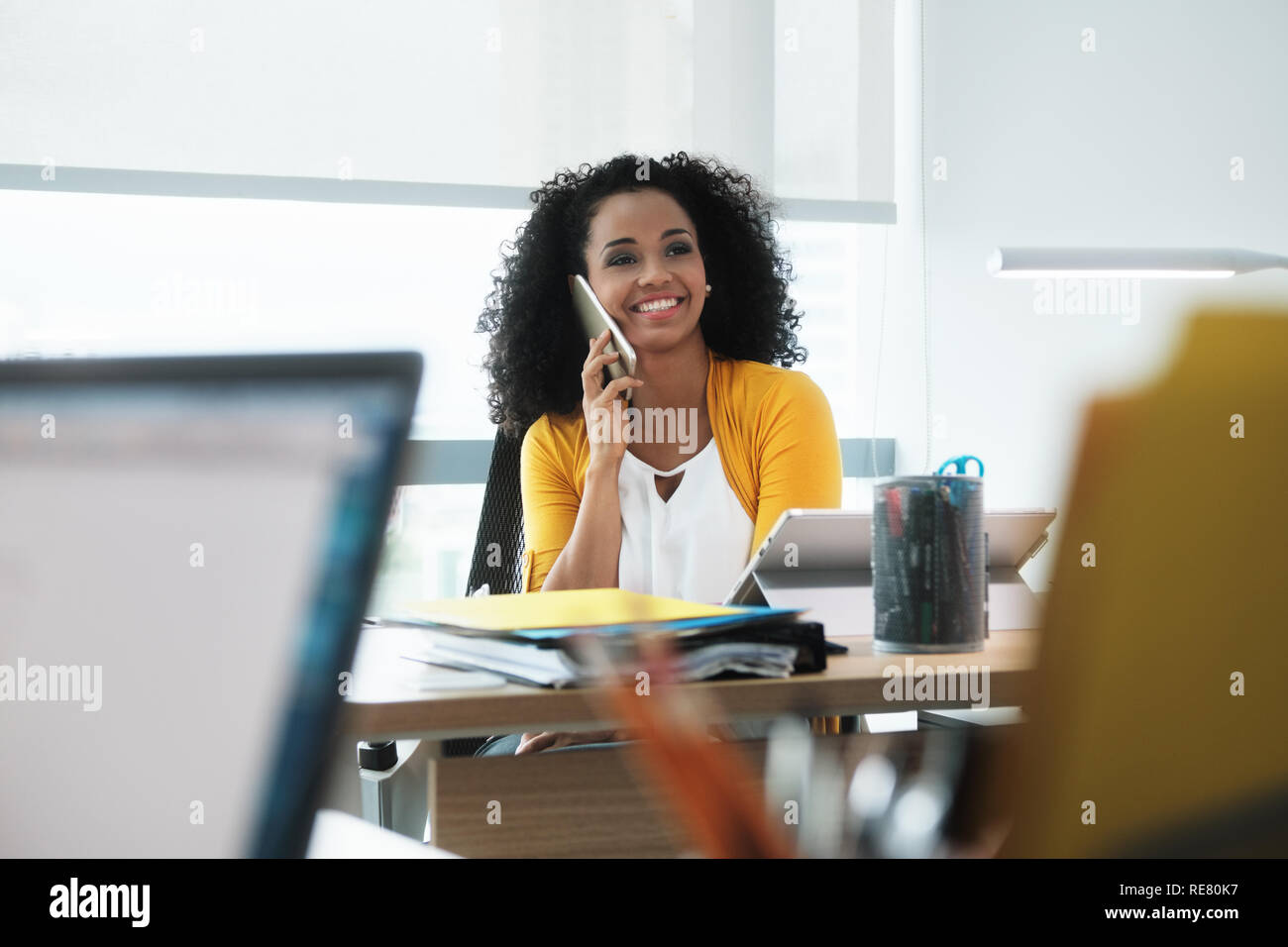 Schöne junge Business Frau mit Handy in Corporate Office Stockfoto