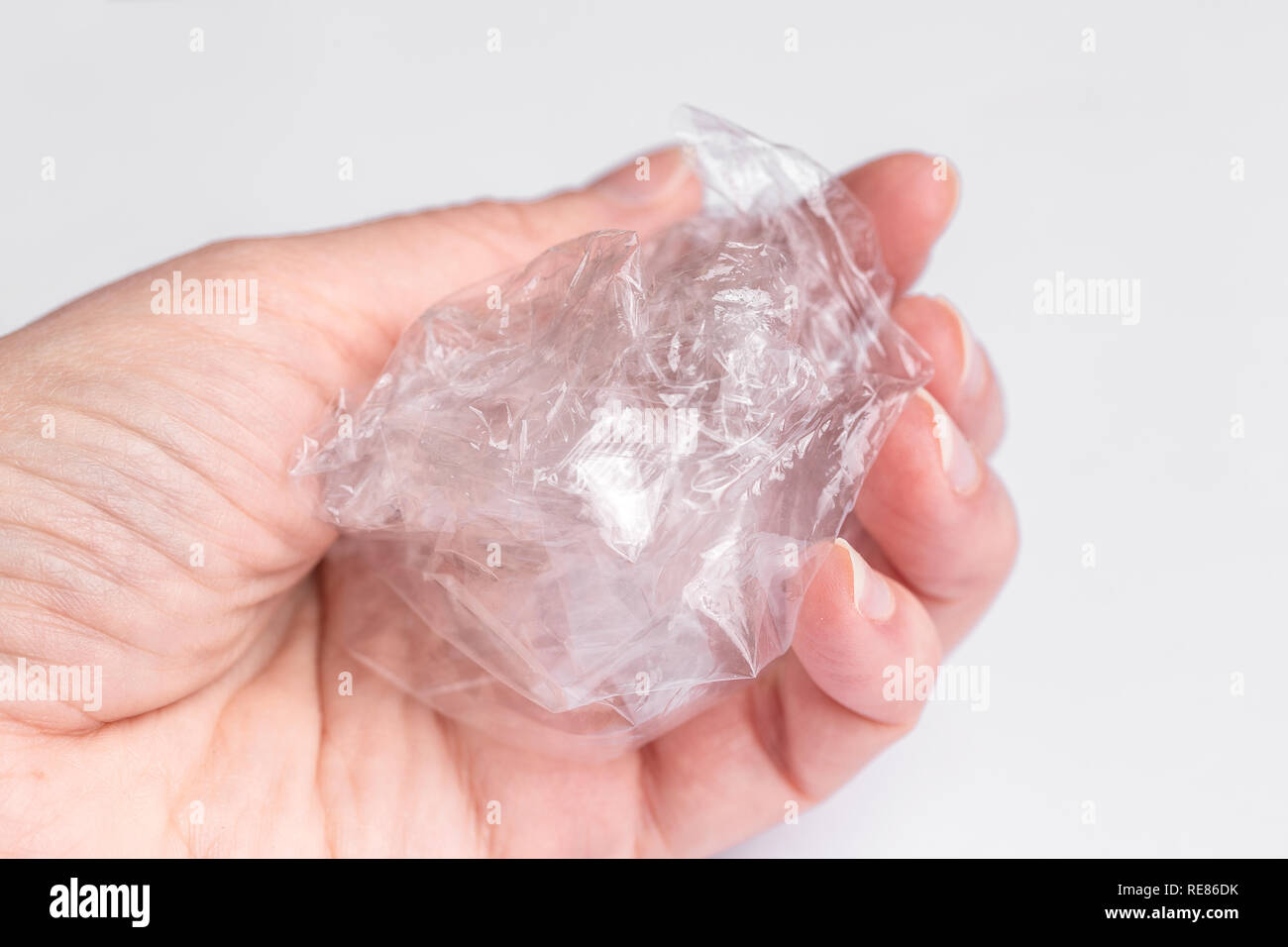 Hält eine Frau in der Hand einem Zerknitterten transparenter Tasche. Ökologie, Recycling von Abfällen. Stockfoto