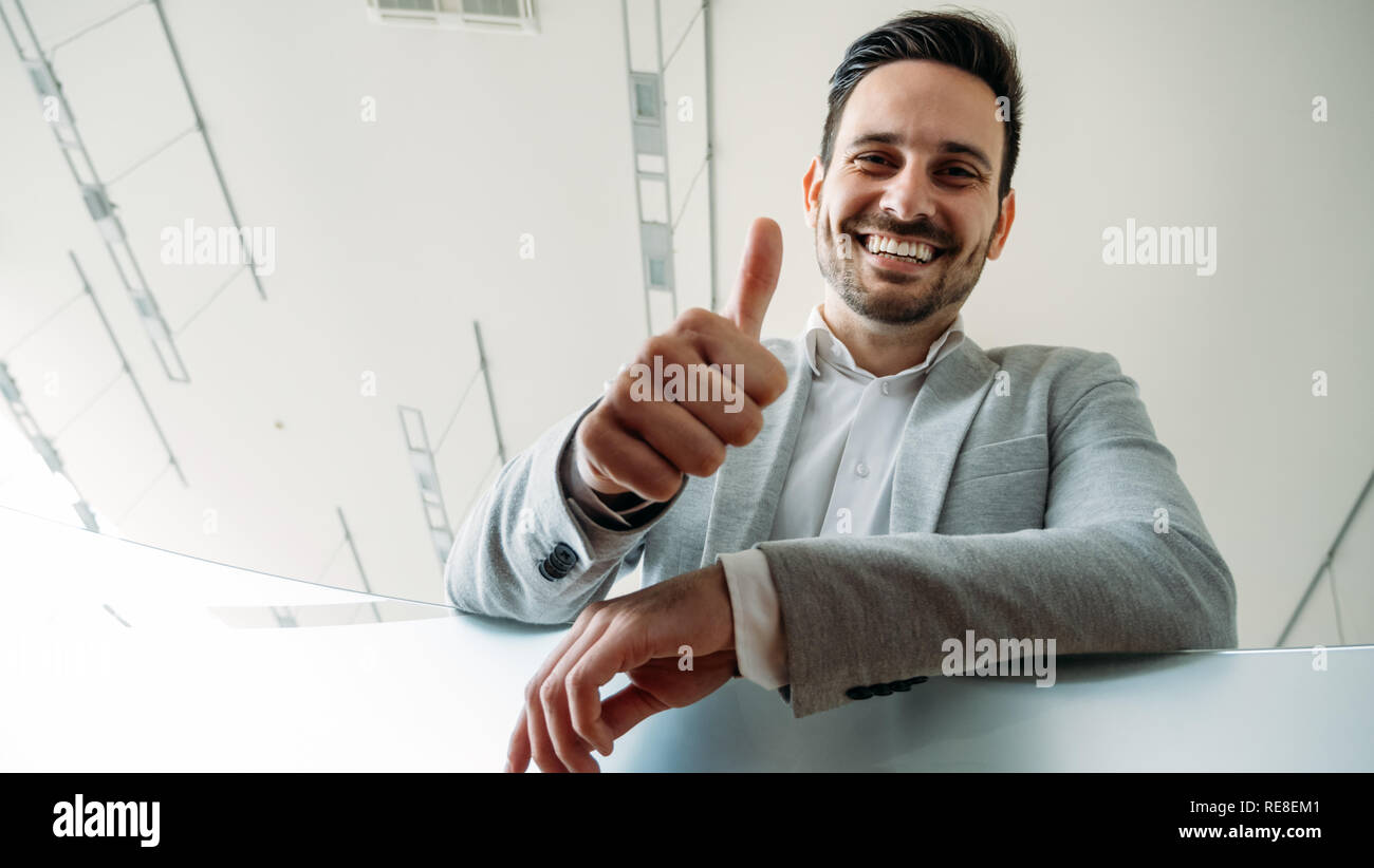 Happy business Mann zeigt Daumen anmelden Geste. Stockfoto