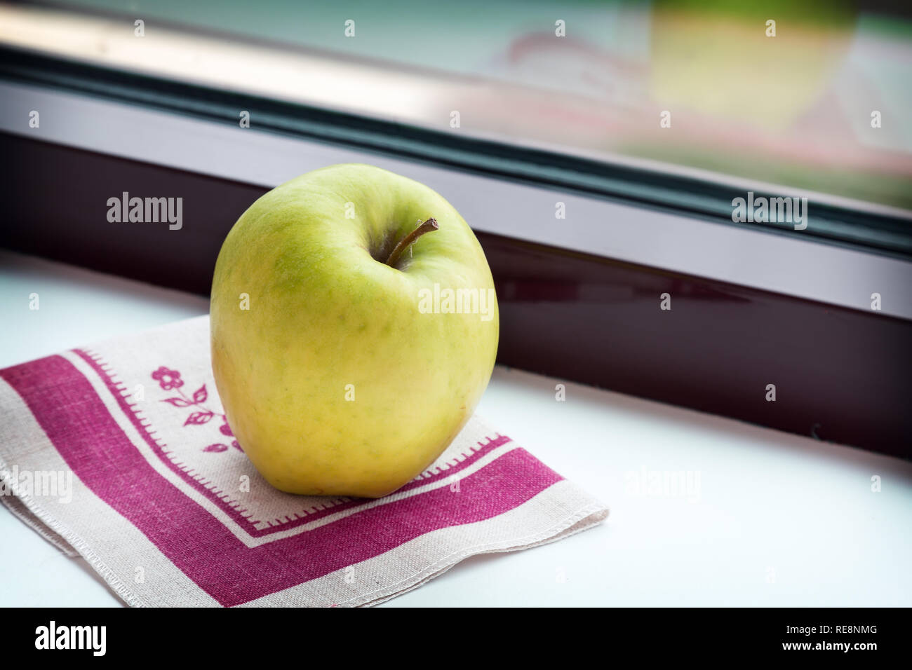 Apple auf eine Serviette auf dem Fensterbrett. Stockfoto
