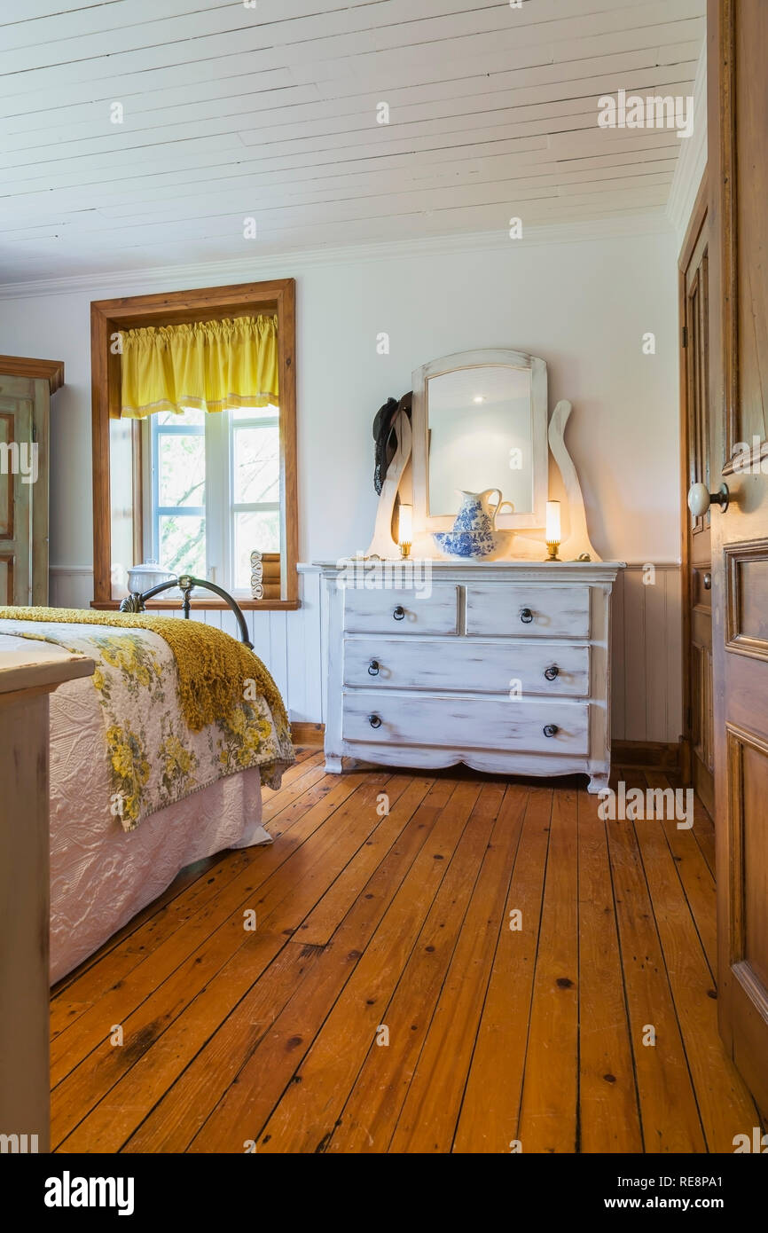 Teilweise mit Blick auf die King size Bett mit weiß und gelb geblümten  Bettüberwurf Creme antik Finish Holz Kommode im Schlafzimmer in der alten  Heimat farbige Stockfotografie - Alamy